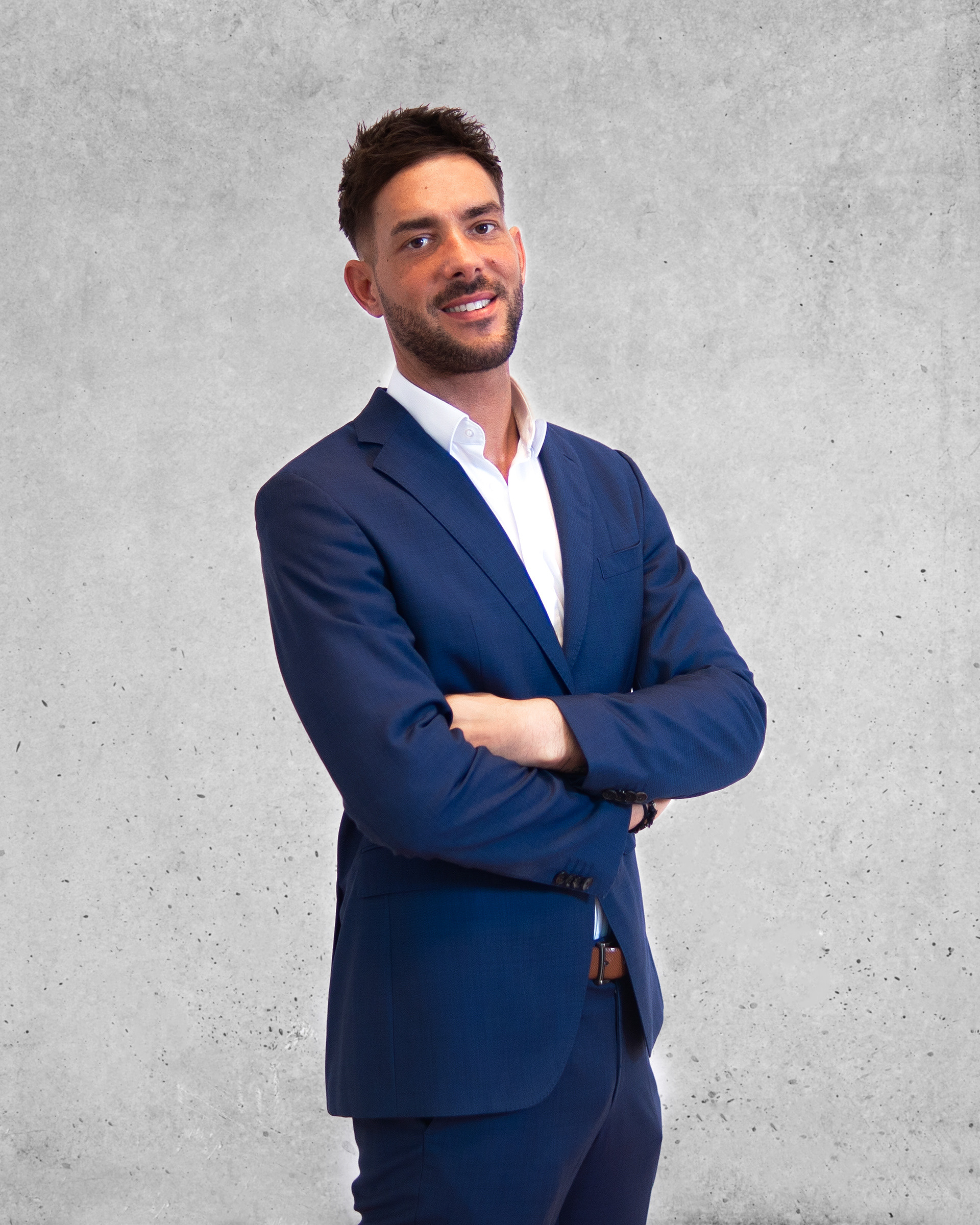 Professionelles Business-Porträt mit verschränkten Armen: Moderne Corporate-Fotografie vor Betonhintergrund, hochwertiges Imagefoto von Medusa Fotografie Regensburg