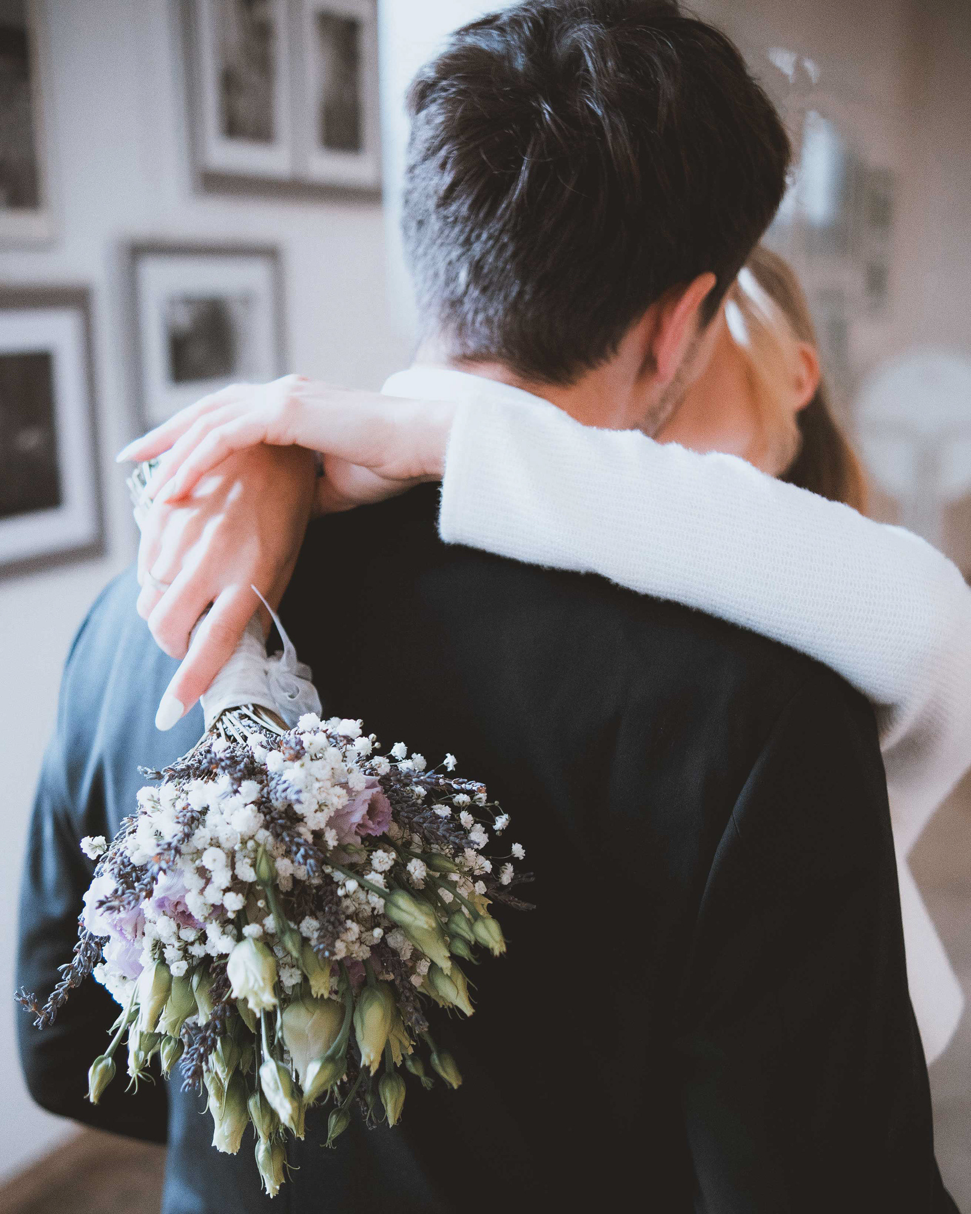 Innige Umarmung des Brautpaares nach der Trauung im Alten Rathaus Regensburg, natürliches Licht und Fokus auf den Brautstrauß, Medusa Fotografie
