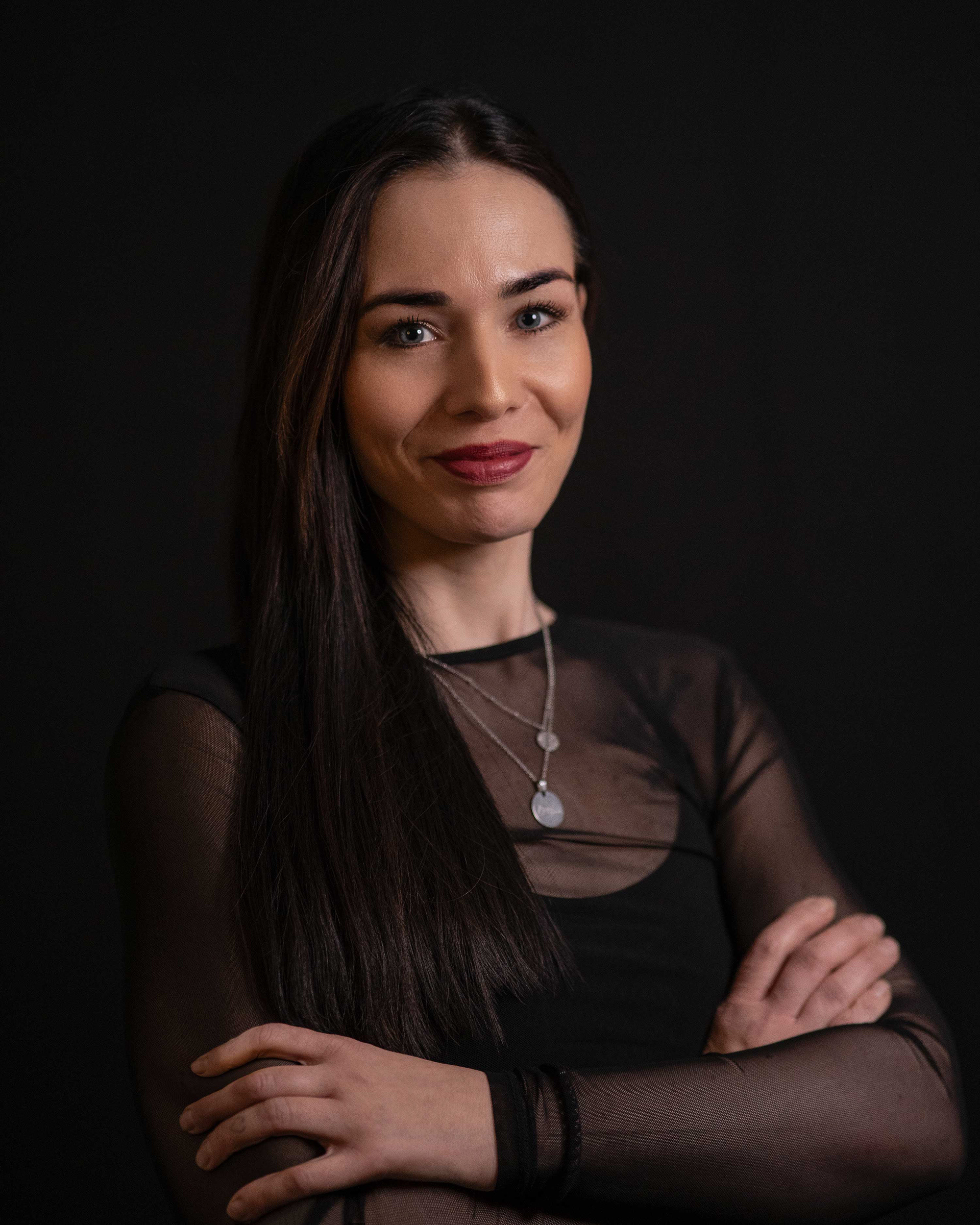 Ausdrucksstarkes Porträtfoto einer lächelnden Frau in schwarzer Kleidung, fotografiert von Medusa Fotografie – Spezialisten für ausdrucksstarke Porträts in Regensburg