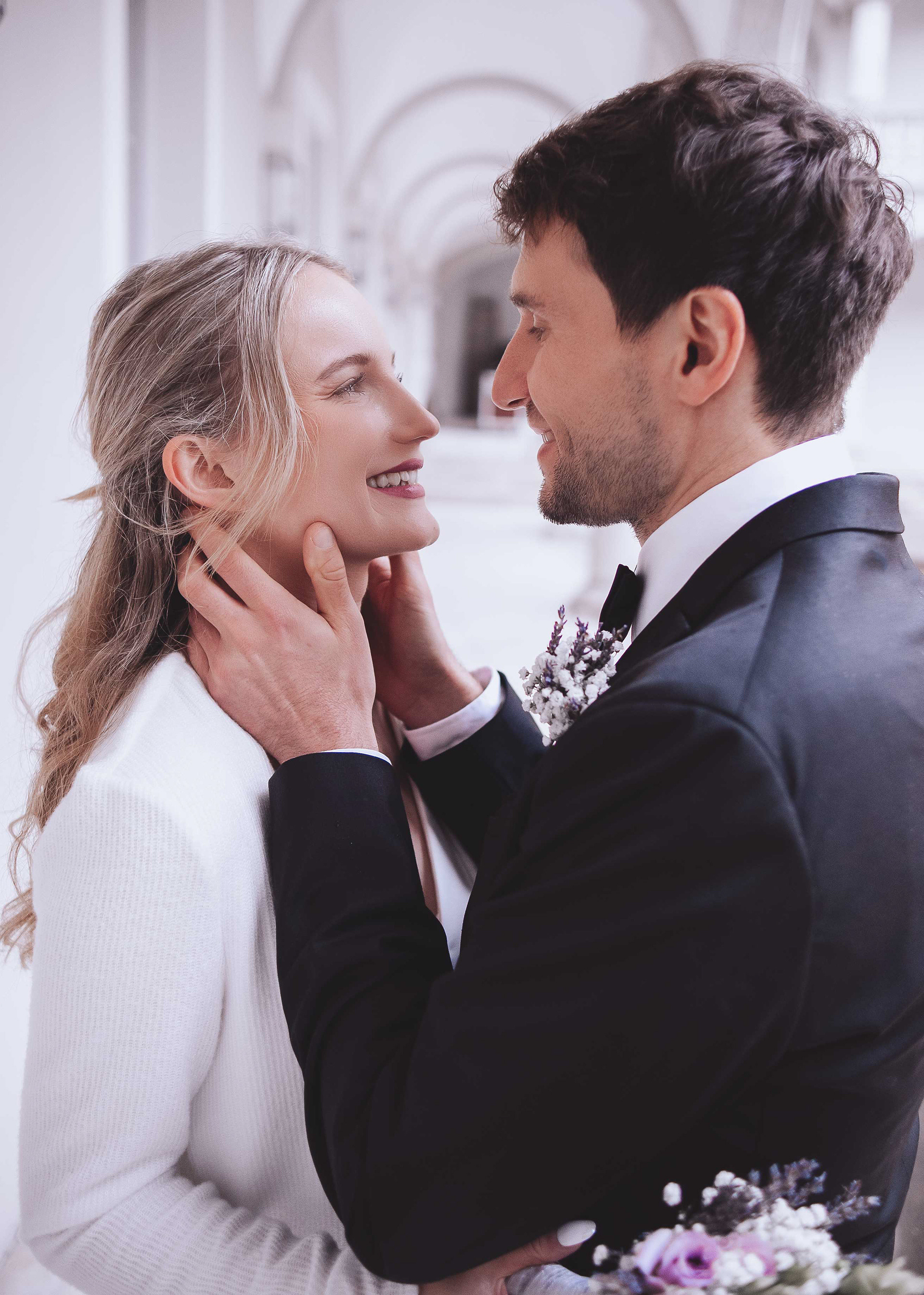 Inniger Moment eines Brautpaares in Regensburg: Der Bräutigam hält das Gesicht der lächelnden Braut sanft in seinen Händen. Detailaufnahme der emotionalen Begegnung während eines Hochzeitsshootings von Medusa Fotografie