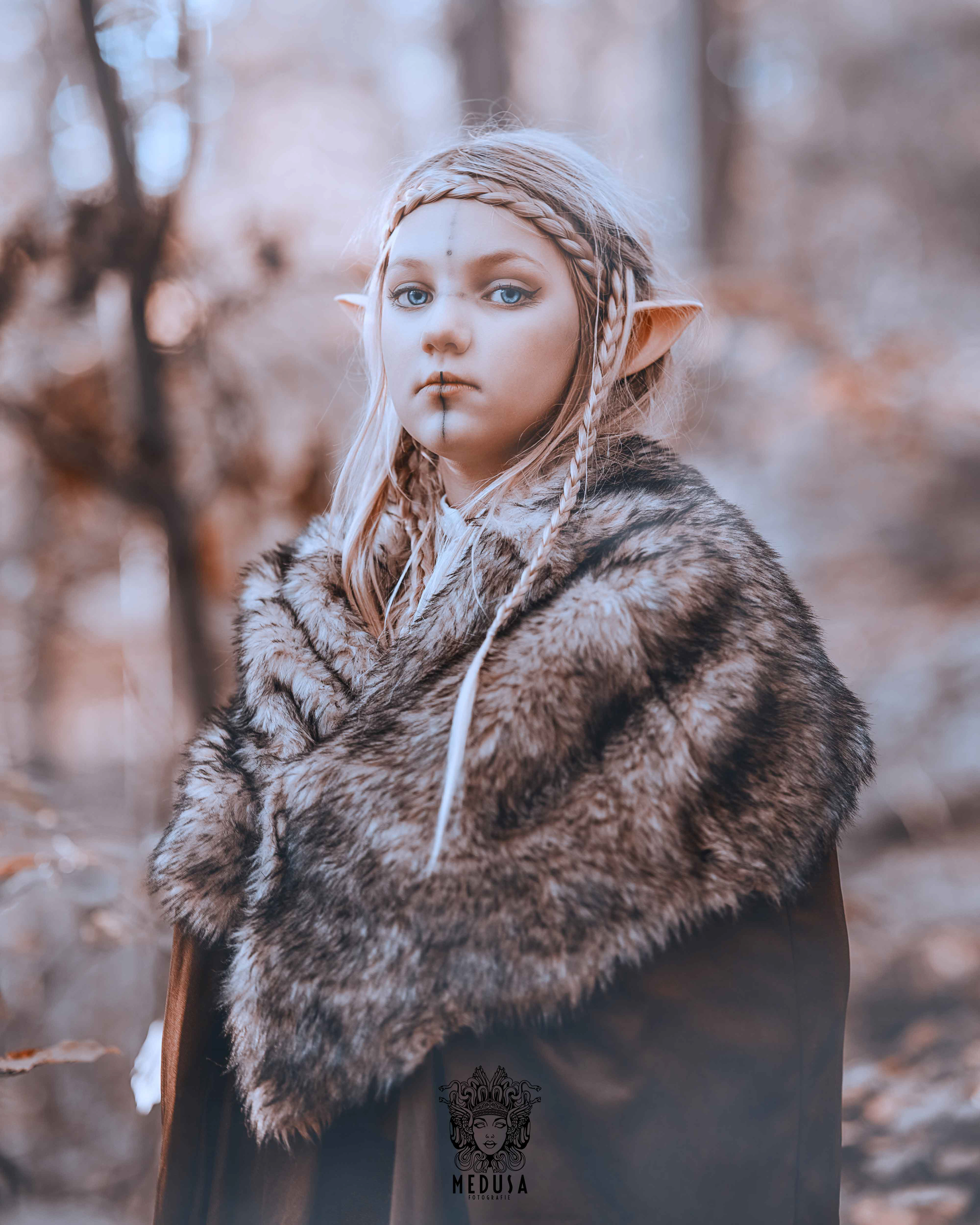 Detailaufnahme eines Elfen Cosplays im Wald mit Fokus auf die Requisiten. Zu sehen sind die Hände der Elfen Kriegerin, die einen hölzernen Bogen halten, sowie ein Pfeil mit einer markanten metallischen Klinge. Fotografiert von Medusa Fotografie