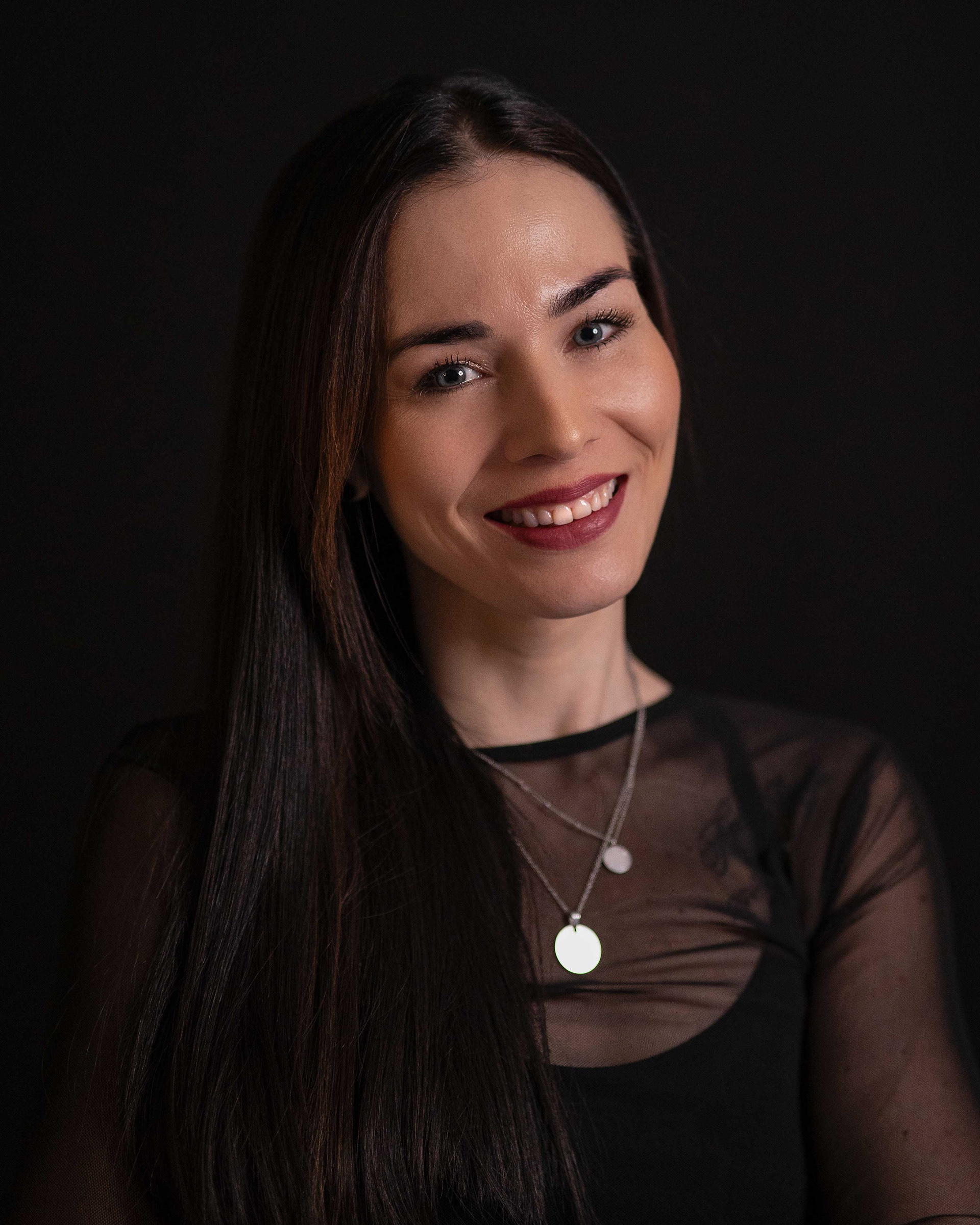 Porträtfoto einer Frau mit dunklen glatten Haaren und silberner Kette in einem Mesh-Oberteil, erstellt von Medusa Fotografie in Regensburg