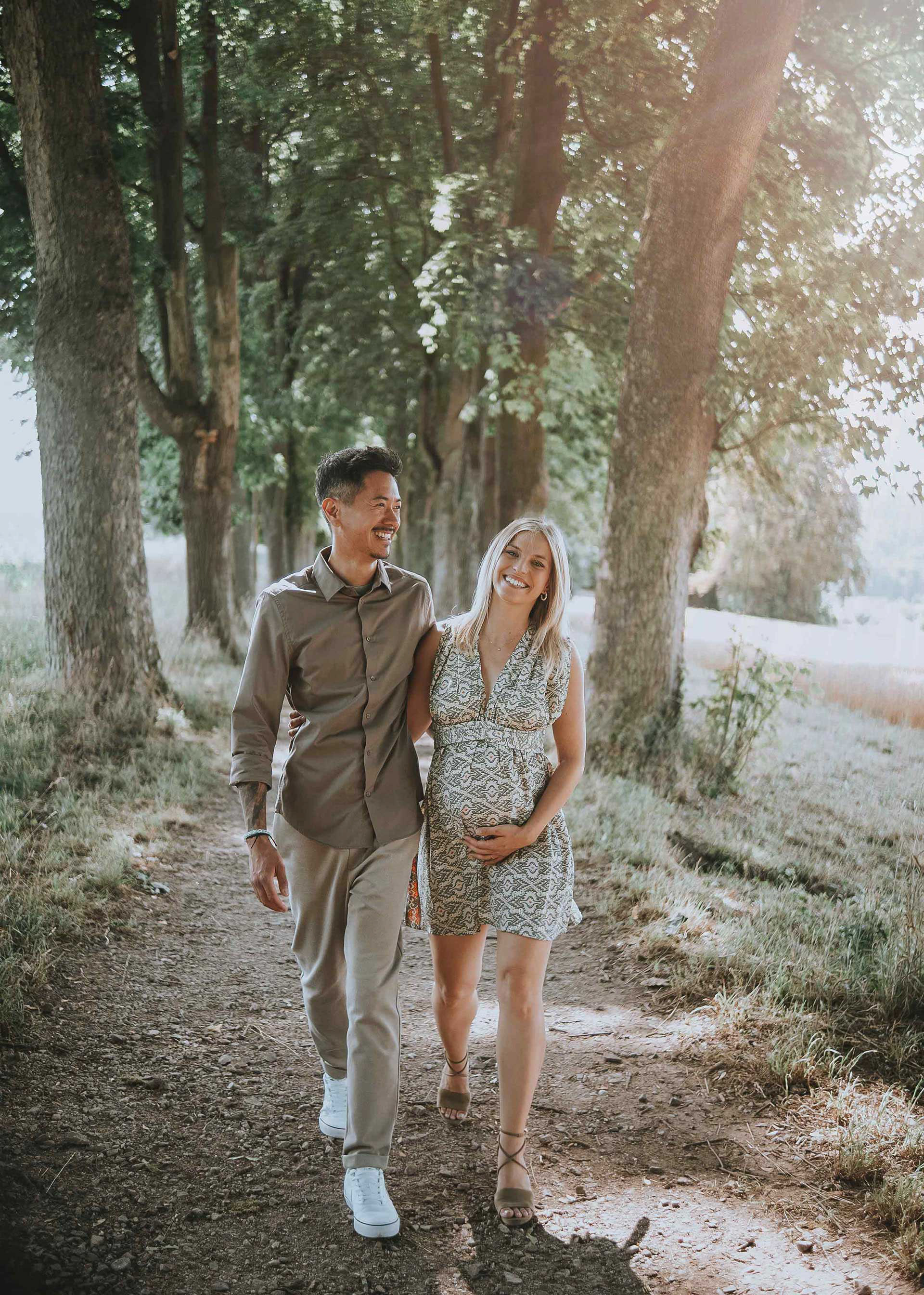 Paar küsst sich zärtlich auf einer Wiese während eines professionellen Schwangerschaftsshootings in Regensburg