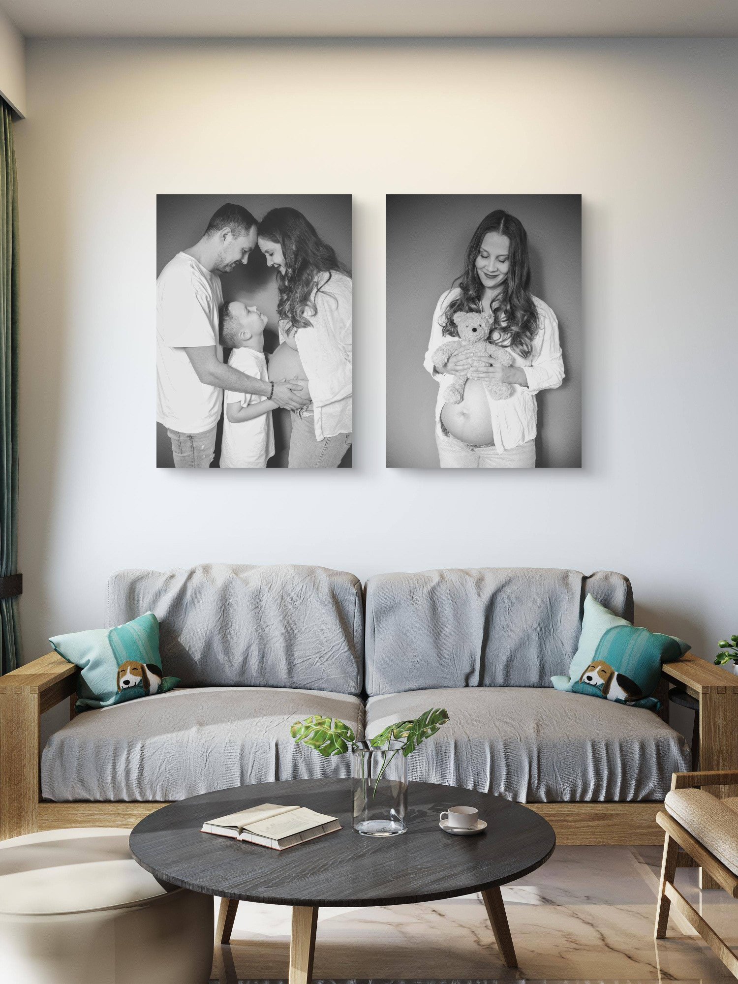 Modernes Wohnzimmer-Interieur mit zwei großen Schwarz-Weiß-Wandbildern: Ein emotionales Schwangerschafts-Paarfoto und ein Babybauch-Porträt der werdenden Mutter mit einem Teddy, aufgenommen von Medusa Fotografie Regensburg