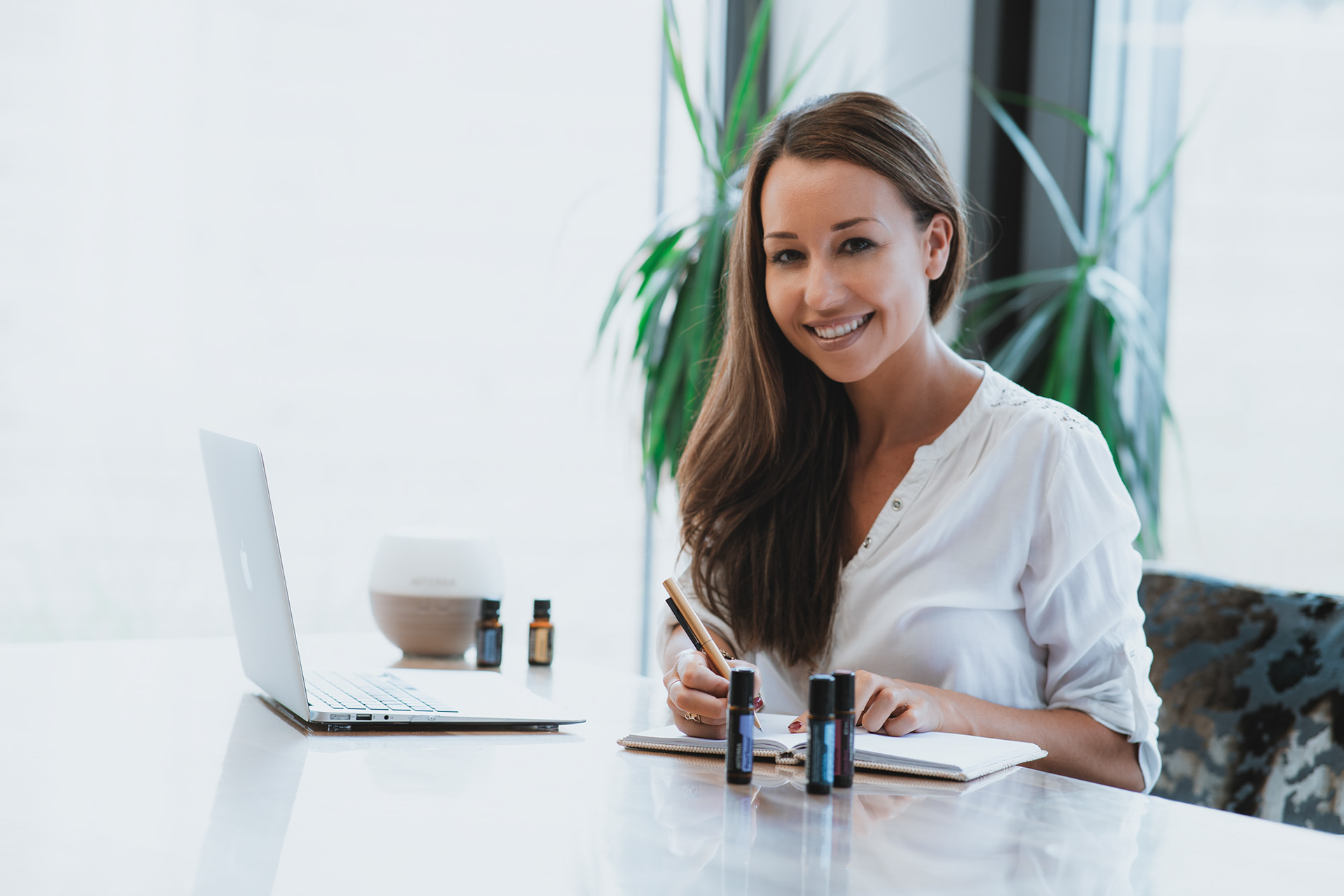 Professionelle Werbefotografie für Coaches und Wellness-Berater: Porträt einer Frau am Schreibtisch mit ästhetischen ätherischen Ölen, moderne Businessbilder von Medusa Fotografie Regensburg