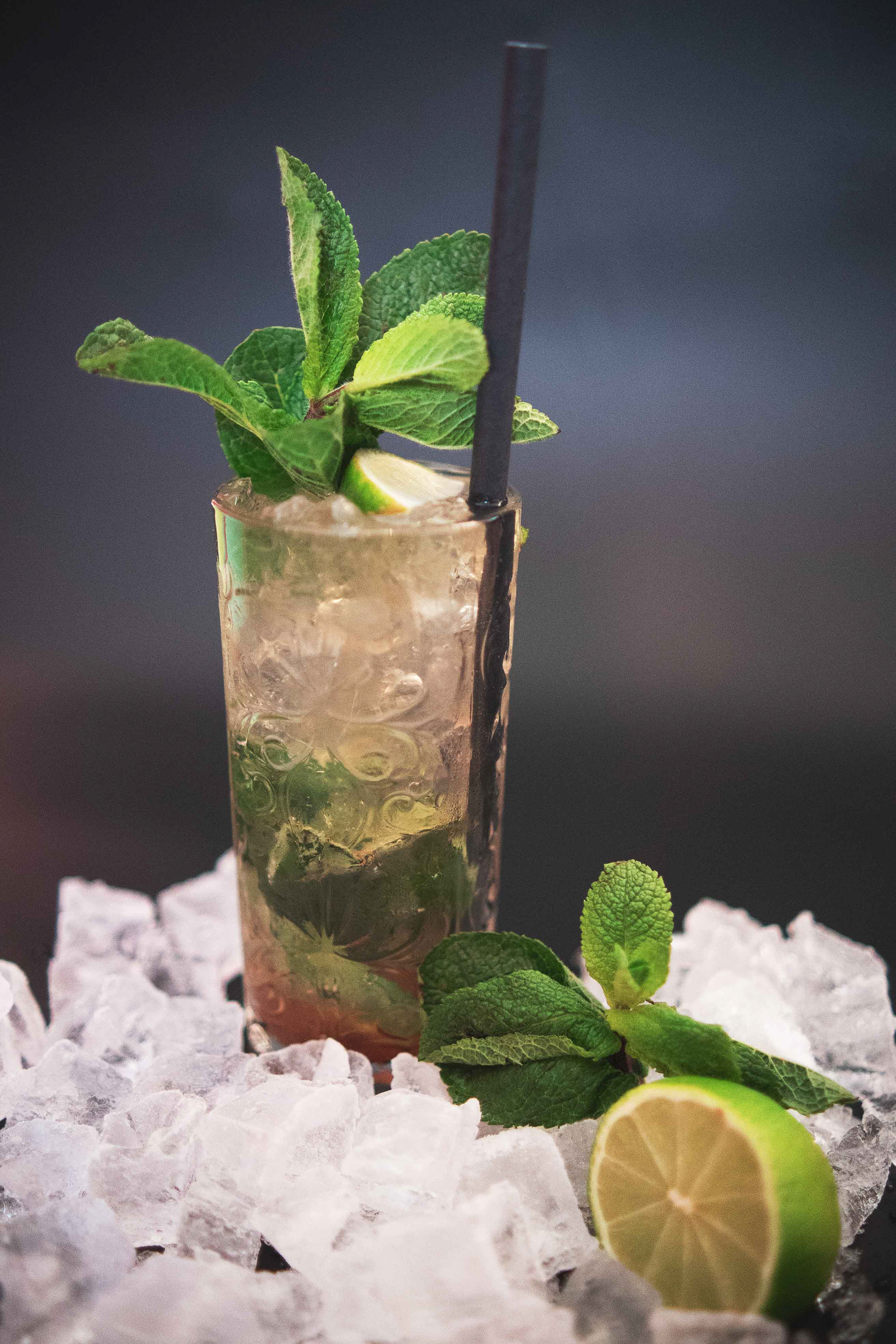 Hochwertiges Cocktail-Foto eines farbenfrohen Drinks mit Eiswürfeln und frischer Garnitur auf einer edlen Restaurant-Theke