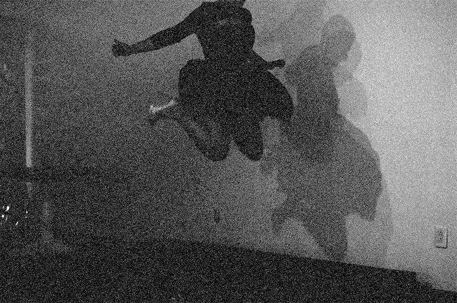 This is a photograph of the performance I'm Fine in philly. The image is blackand white and is extremely grainy. I am jumping and my head is out of the frame but you see my head in the shadow on the wall. I am not wearing a wig and from what I can tell I am wearing my gold stilettos.
