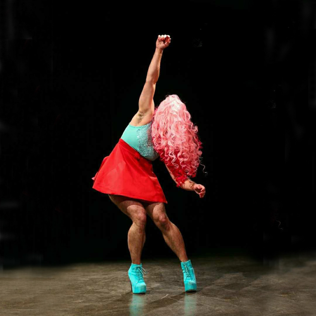 Both my feet are planted firmly on the ground. My right arm is directly above my head as if to catch my balance. My hips are at an angle and my torso is leaning a bit to the left and my left arm is swinging out to try to catch my balance. My face is covered by my wig.