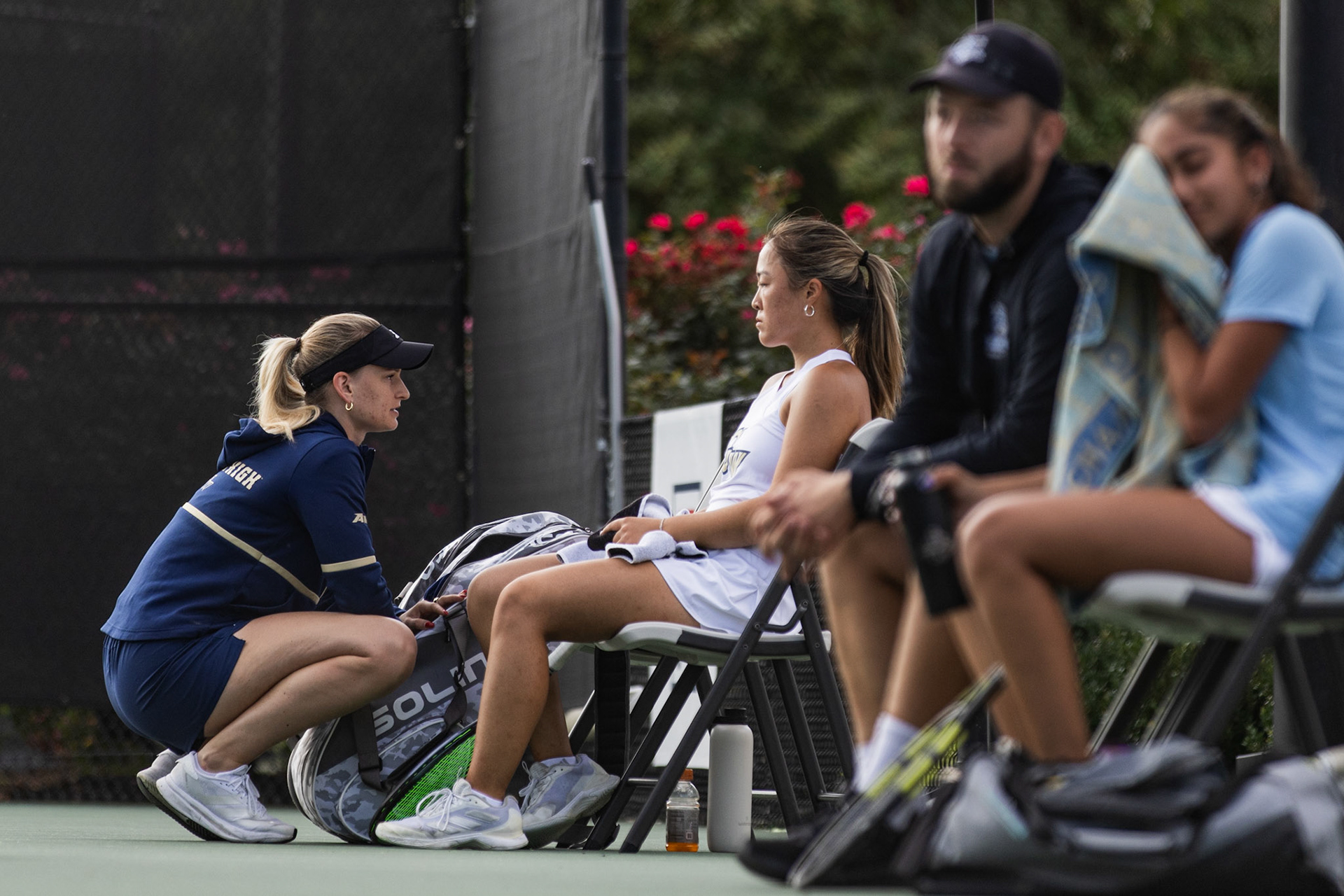 COLLEGE PARK, MARYLAND - SEPTEMBER 20: GW Tennis Assistant Coach Stella Wiesemann speaks to junior Madison Lee between sets of her singles match against Sahara Sanjeev of Johns Hopkins University at the Bedford Cup tournament in College park, Md. on Sept. 20, 2025. Wiesemann graduated from GW last year with 61 singles wins in three seasons, using her experience to guide the team this year as they kick off the new season.