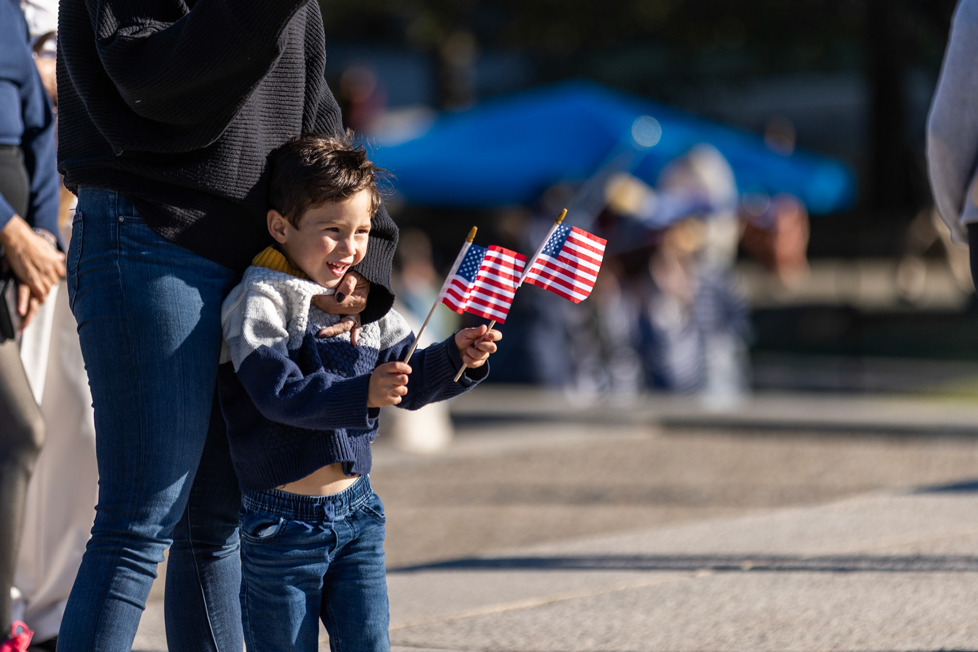 A child waves two American flags during a Unite the DMV rally at the Lincoln Memorial on Oct. 17, 2025. The protest, held on the eve of the No Kings march that drew millions across the nation, featured speakers and dancing to bring together community members in defense of democracy.