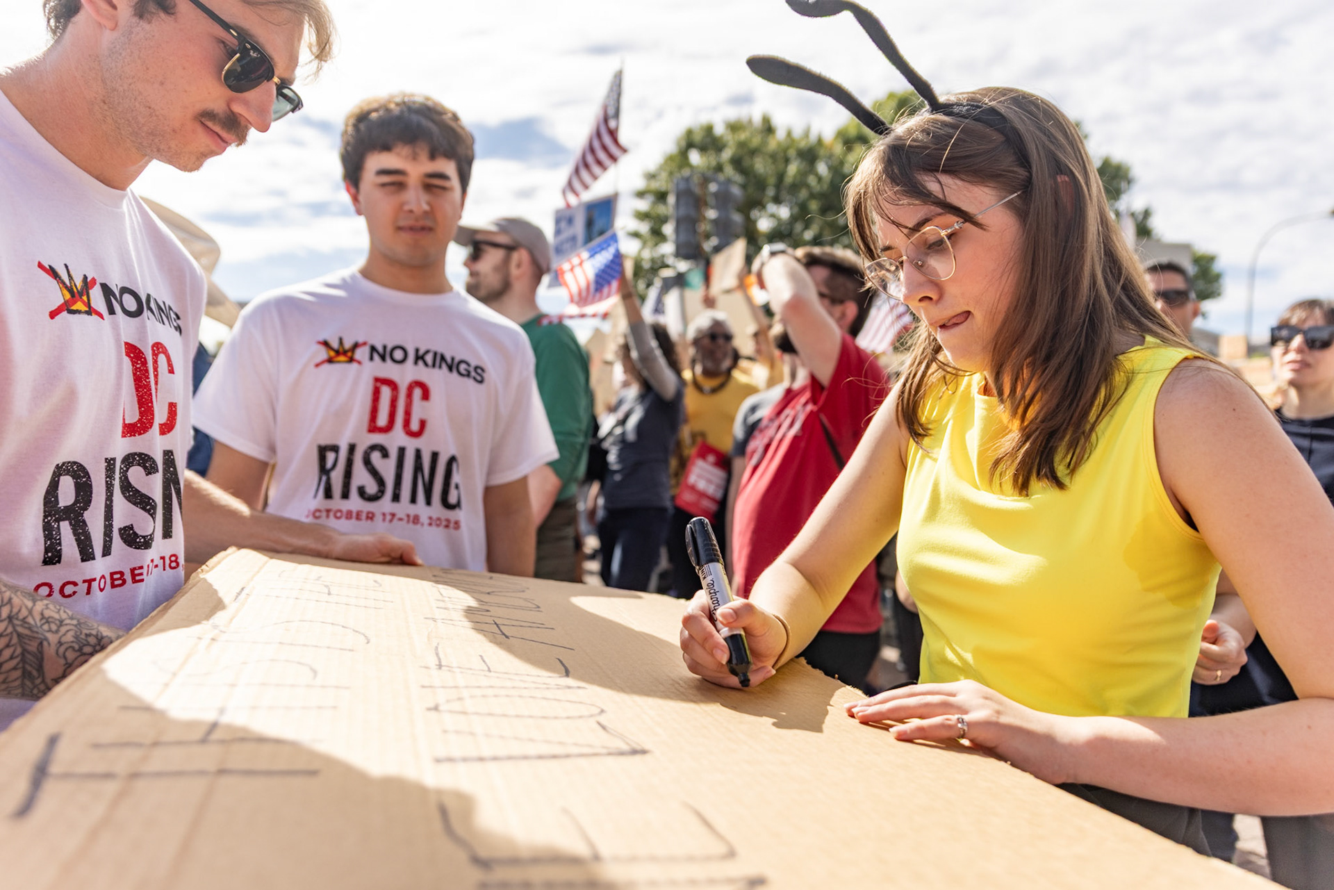 Dressed as a bumblebee, a protestor writes on a sign at the No Kings protest in Washington, D.C. on Oct.18, 2025. Over 7 million people across the country marched against recent actions by President Trump, from the immigration crackdown to the general state of the economy.