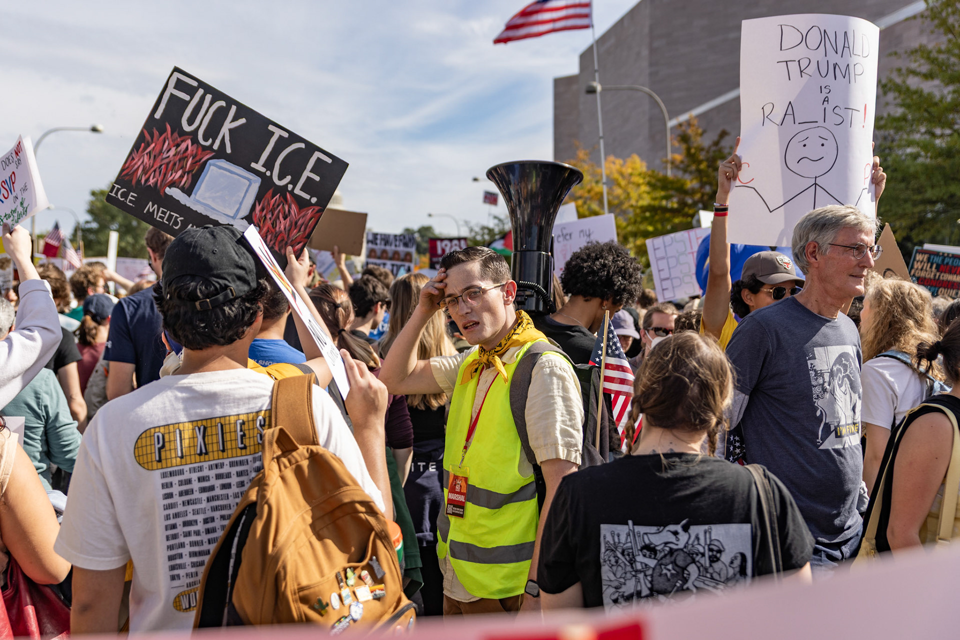 Surrounded by protestors cheering along Pennsylvania Avenue, a volunteer organizer at the No Kings protest looks around on Oct. 18, 2025. Over 7 million people across the country marched against recent actions by President Trump, from the immigration crackdown to the general state of the economy.