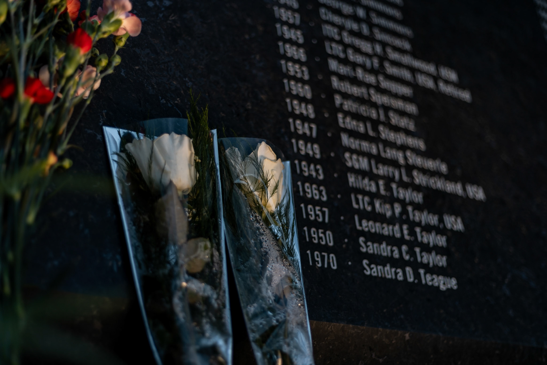 ARLINGTON, VIRGINIA - SEPTEMBER 11: Flowers rest against a plaque at the entrance to the 9/11 Pentagon Memorial commemorating all the victims of the attack for the 24th anniversary on Sept. 11, 2025. Completed in 2008, the site consists of 184 illuminated benches arranged by age, each one dedicated to a victim either in the building or on the flight at the time of the crash.