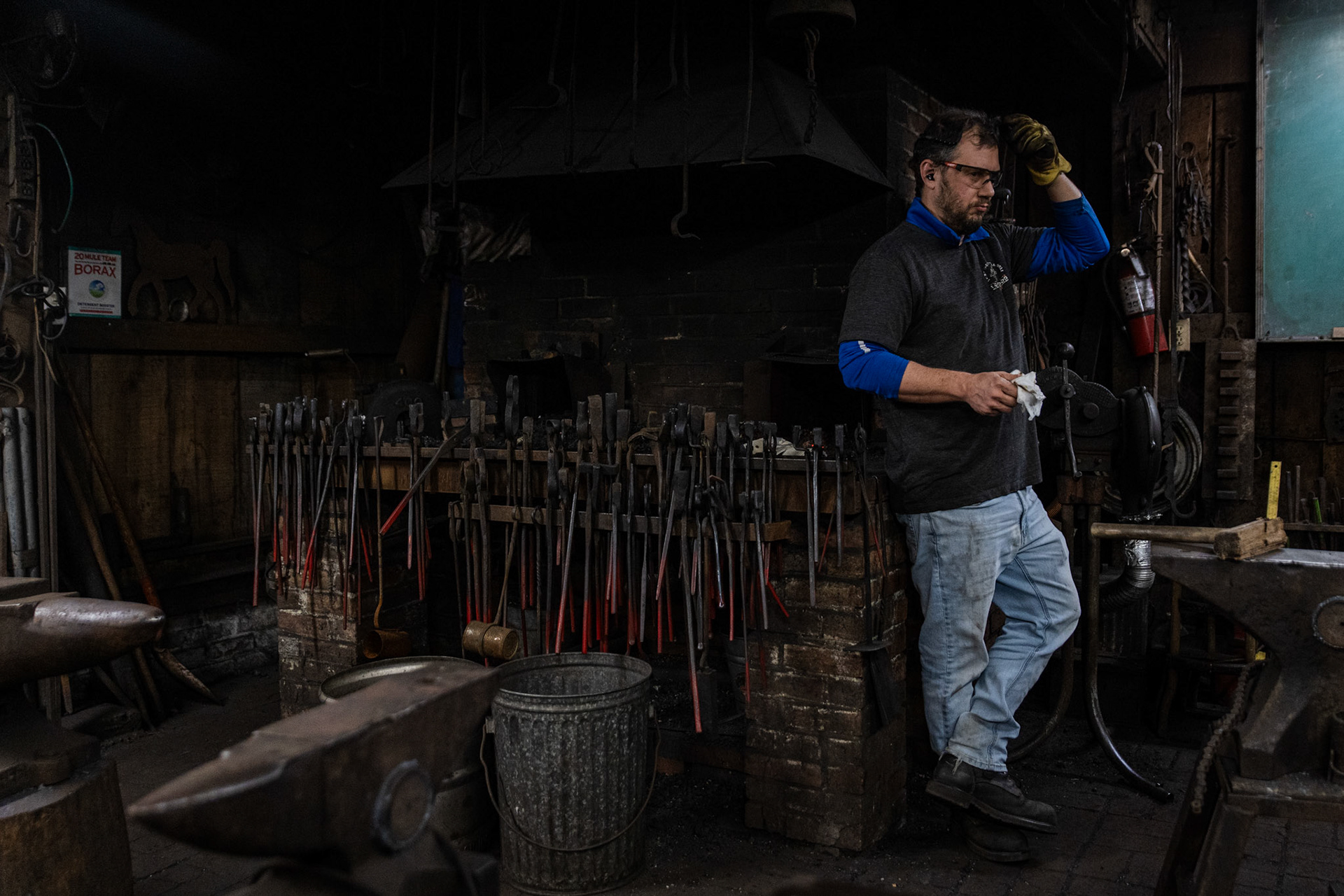 A member of the Blacksmiths Guild of the Potomac rests against the forge while waiting for his iron to cool in Arlington, Va. on Nov. 10, 2025.
