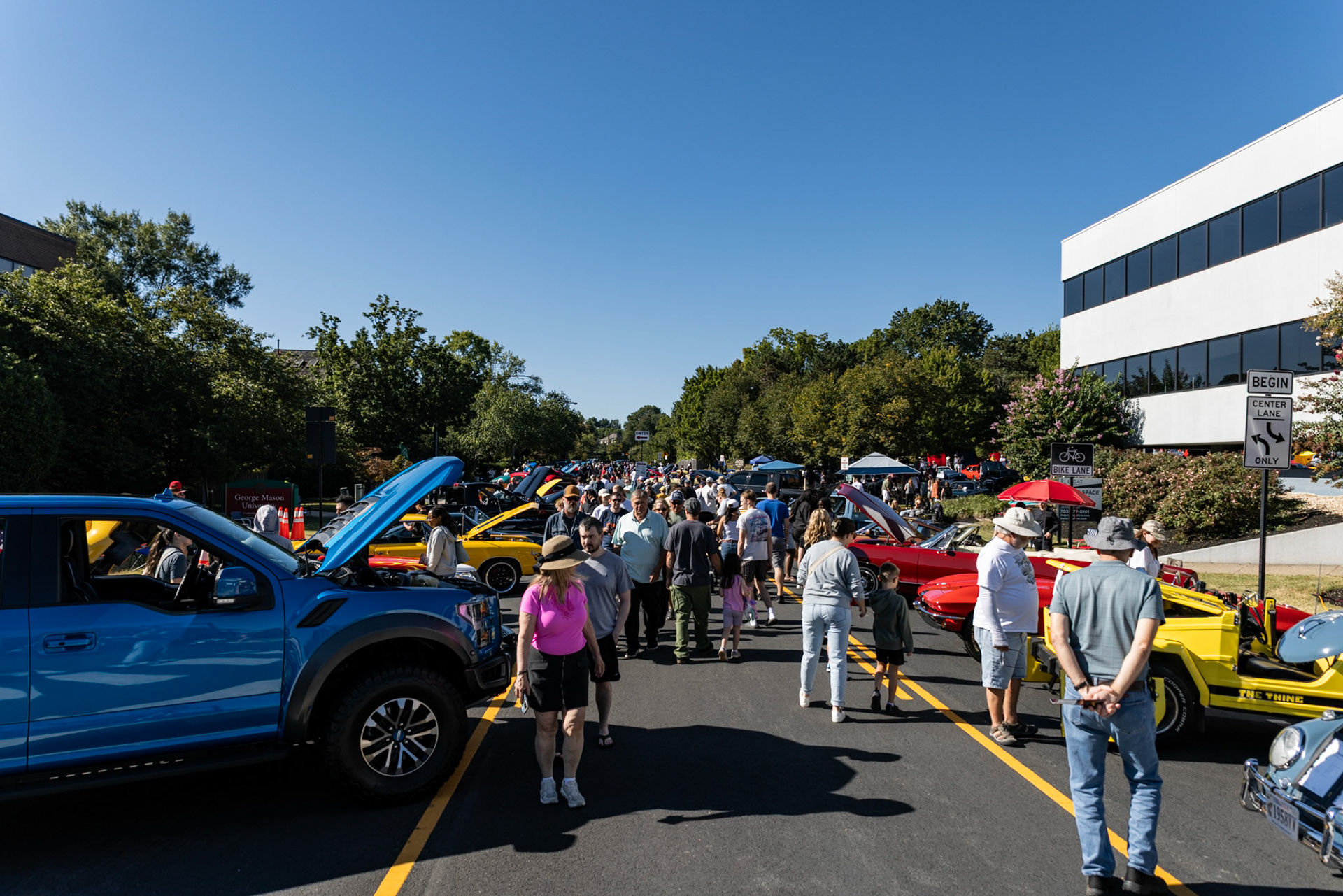 FAIRFAX, VIRGINIA - SEPTEMBER 01: Surrounded by cars and vendors, people walk along University Drive at the 26th Annual Fairfax County Labor Day Car Show on September 1, 2025. The show, welcoming families from around the area to celebrate Labor Day and support local charities, featured over 250 vehicles competing for a variety of awards.