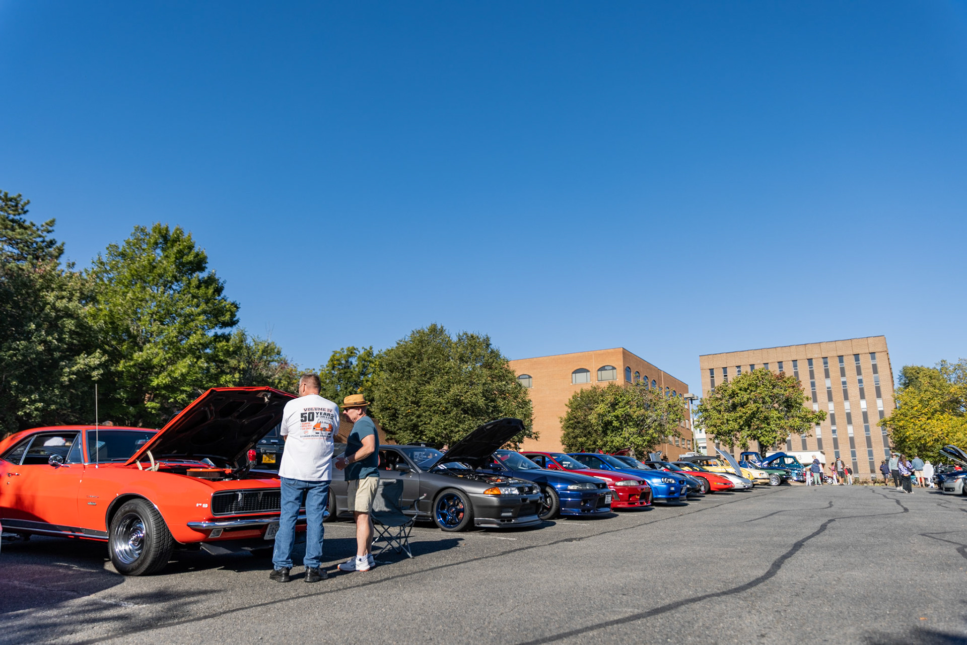 FAIRFAX, VIRGINIA - SEPTEMBER 01: Participants in the 26th Annual Fairfax County Labor Day Car Show assess the engine of a Chevrolet Camaro RS before the event starts on September 1, 2025. The show, welcoming families from around the area to celebrate Labor Day and support local charities, featured over 250 vehicles competing for a variety of awards.