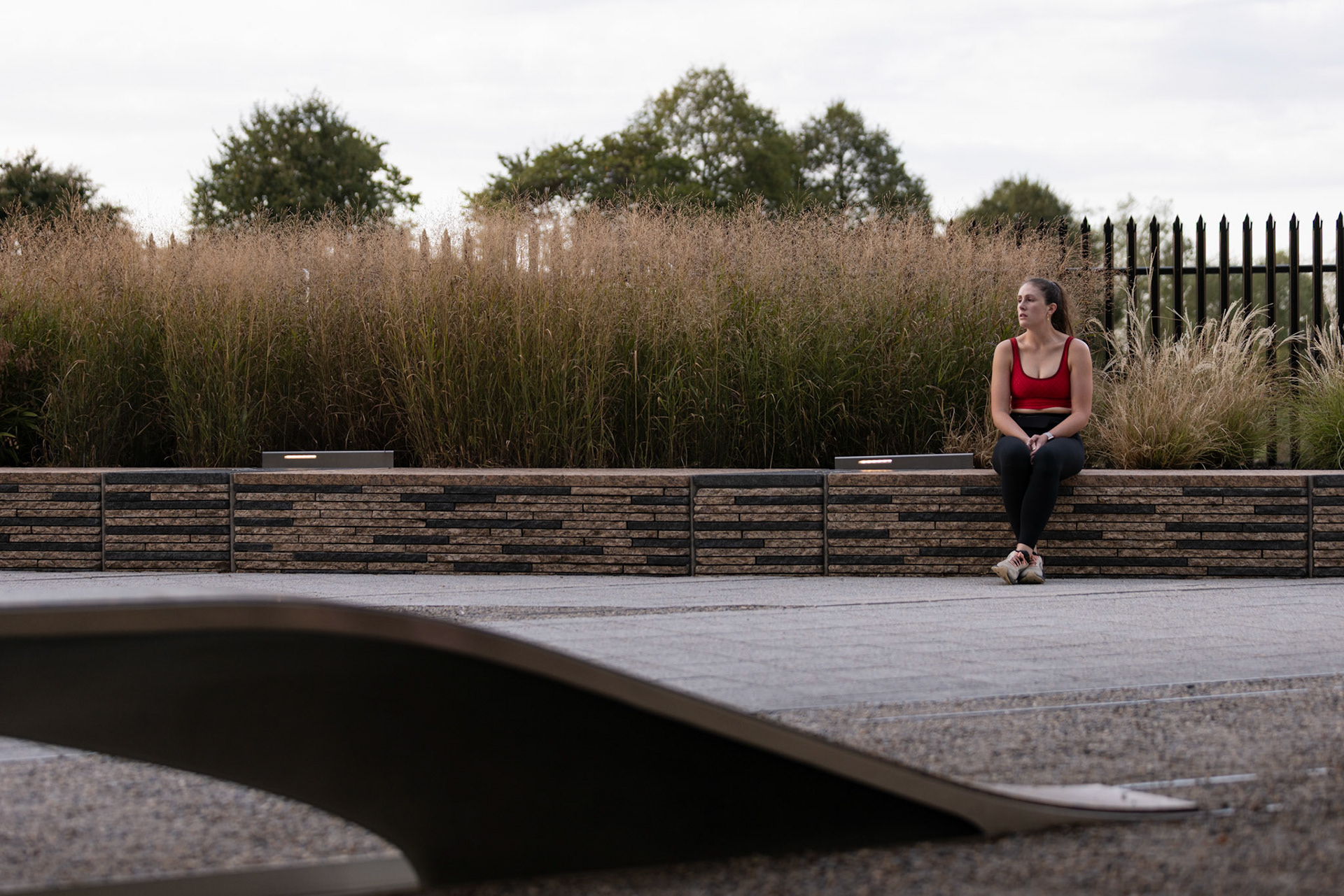 ARLINGTON, VIRGINIA - SEPTEMBER 11: A visitor sits along the wall of the 9/11 Pentagon Memorial on Sept. 11, 2025, beginning to tear up while looking over the memorial. Completed in 2008, the site consists of 184 illuminated benches arranged by age, each one dedicated to a victim either in the building or on the flight at the time of the crash.