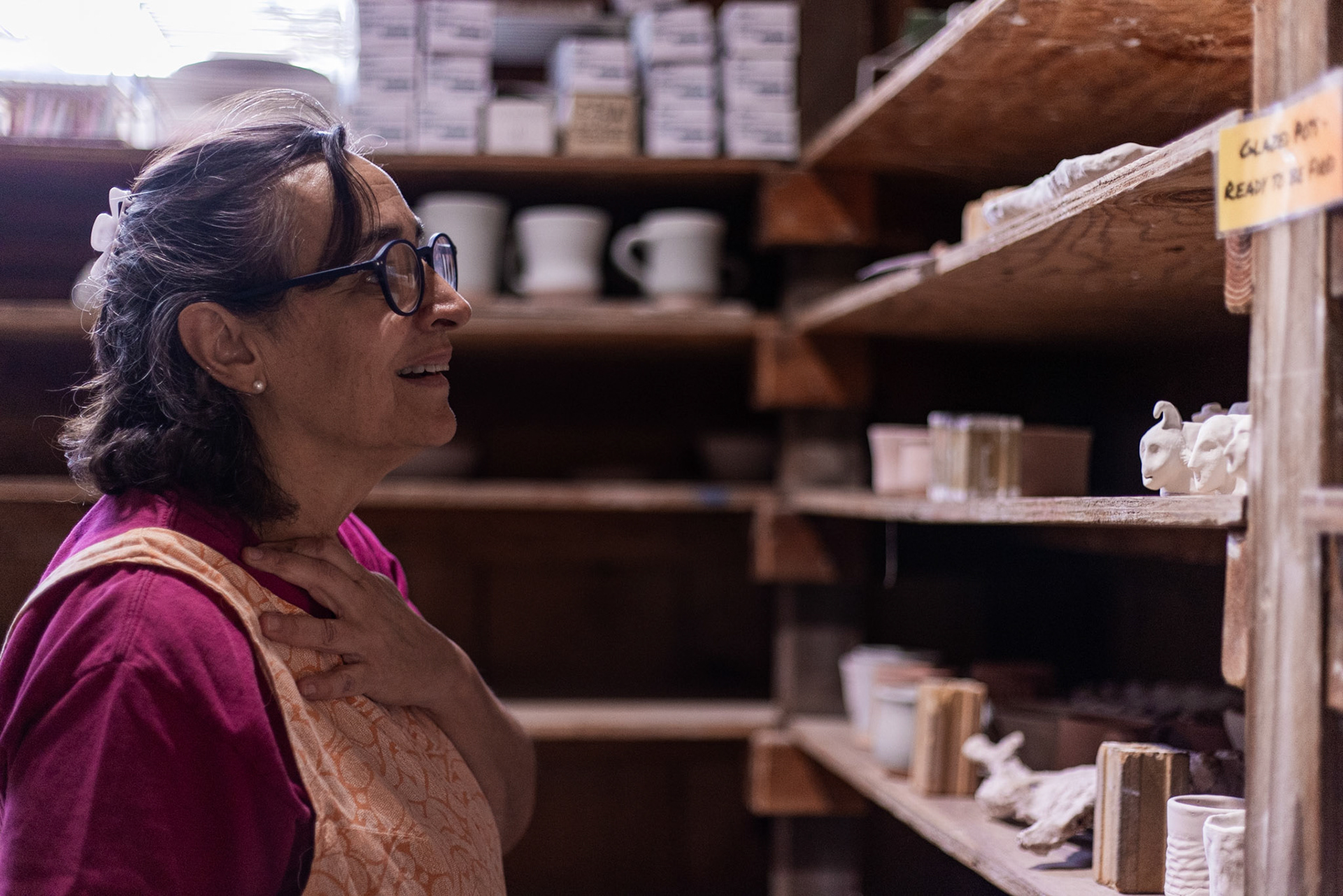 LLooking over the shelves of pieces ready to be glazed, Beatriz Pinto admires the work of her peers at Glen Echo Pottery in Glen Echo, Md. on Sept. 28, 2025.