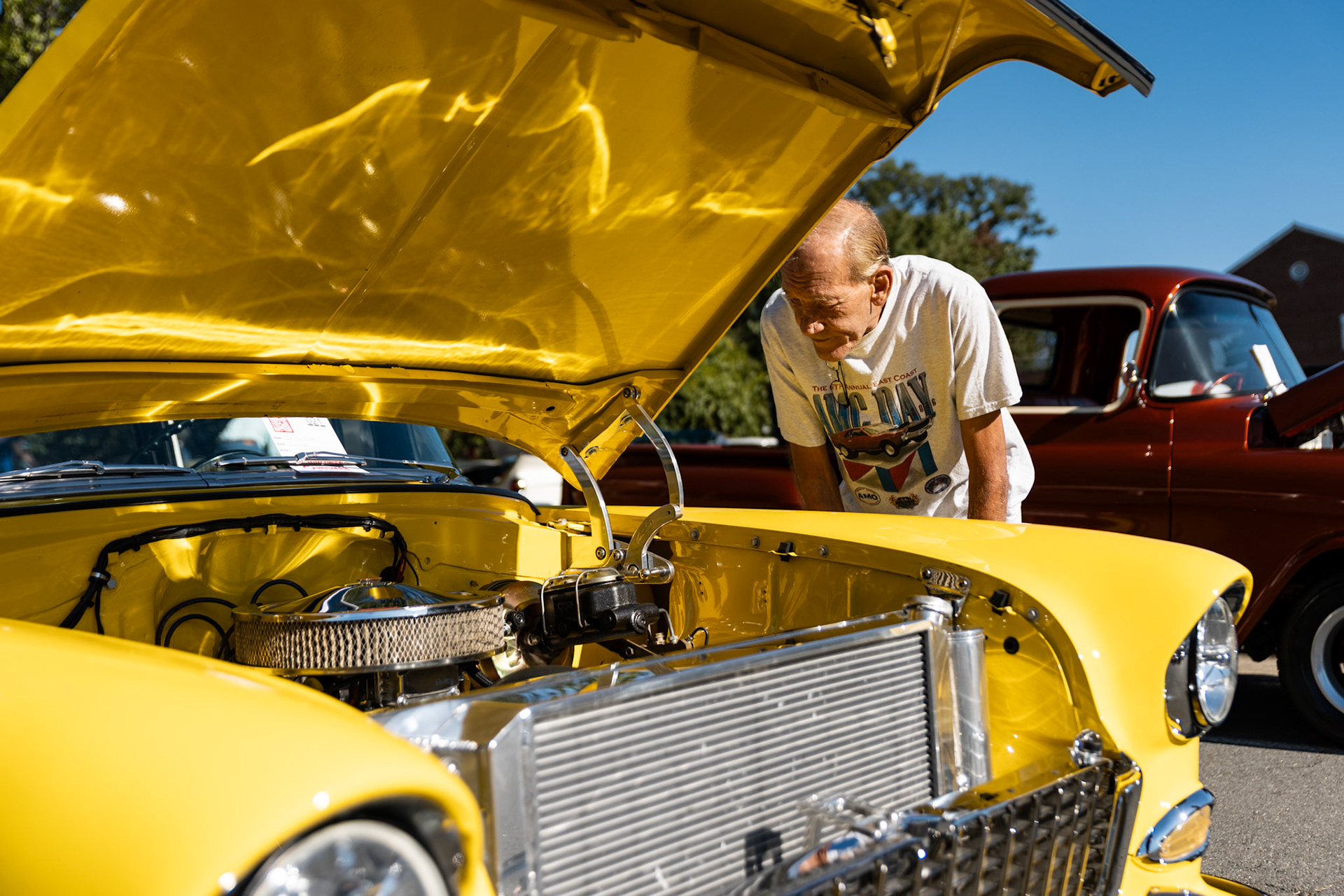 FAIRFAX, VIRGINIA - SEPTEMBER 01: An attendee at the 26th Annual Fairfax County Labor Day Car Show looks at the engine of a Chevrolet 210 on September 1, 2025. The show, welcoming families from around the area to celebrate Labor Day and support local charities, featured over 250 vehicles competing for a variety of awards.