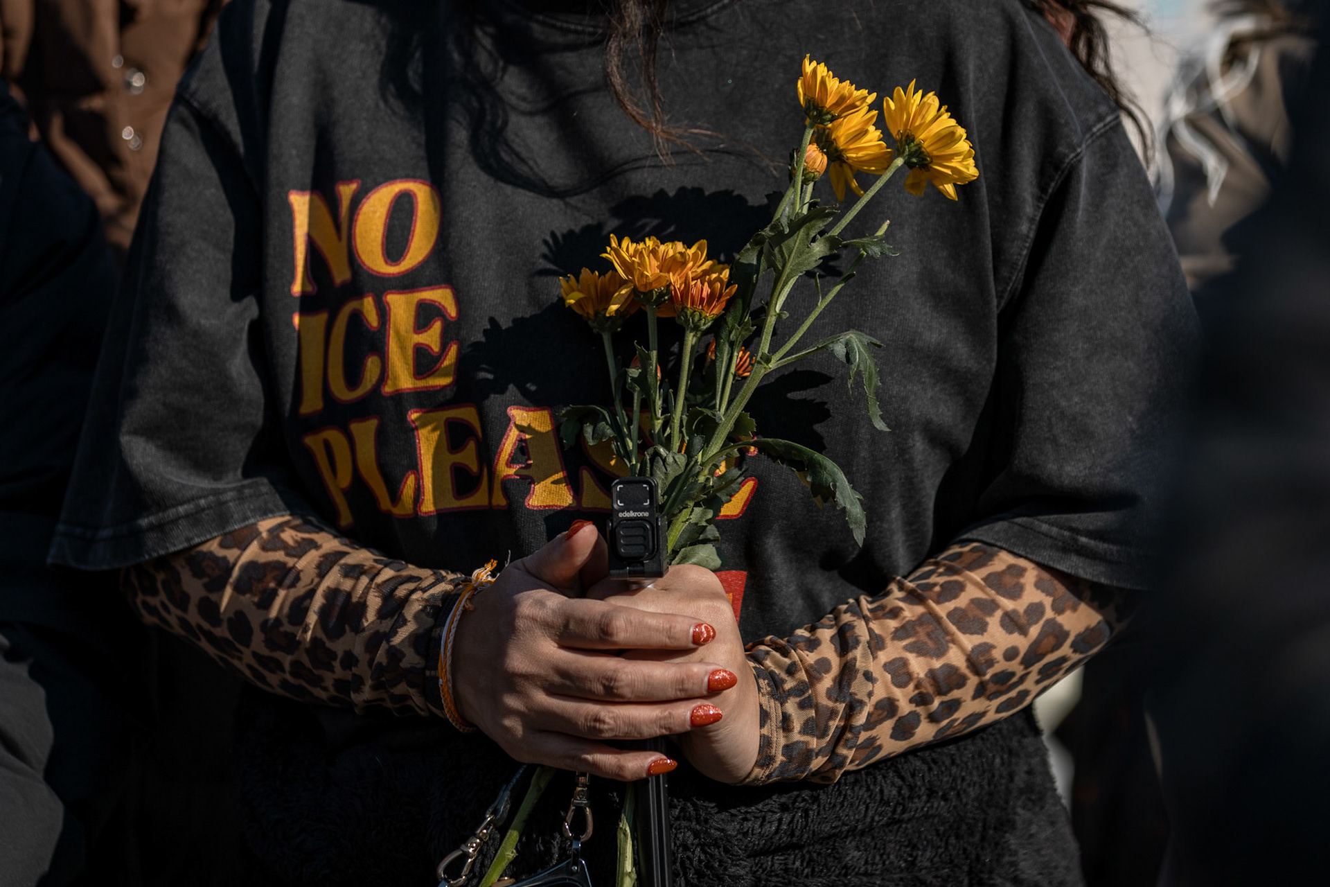 Donning a shirt protesting recent Immigration and Customs Enforcement activity, a participant holds flowers during the closing remarks of the monks’ Walk for Peace at the Lincoln Memorial on Feb. 11, 2026. A group of 18 monks began their march to raise awareness of “peace, loving kindness and compassion” in the United States and the world on Oct. 26 in Fort Worth, Texas, ending with their arrival in the nation's capital.