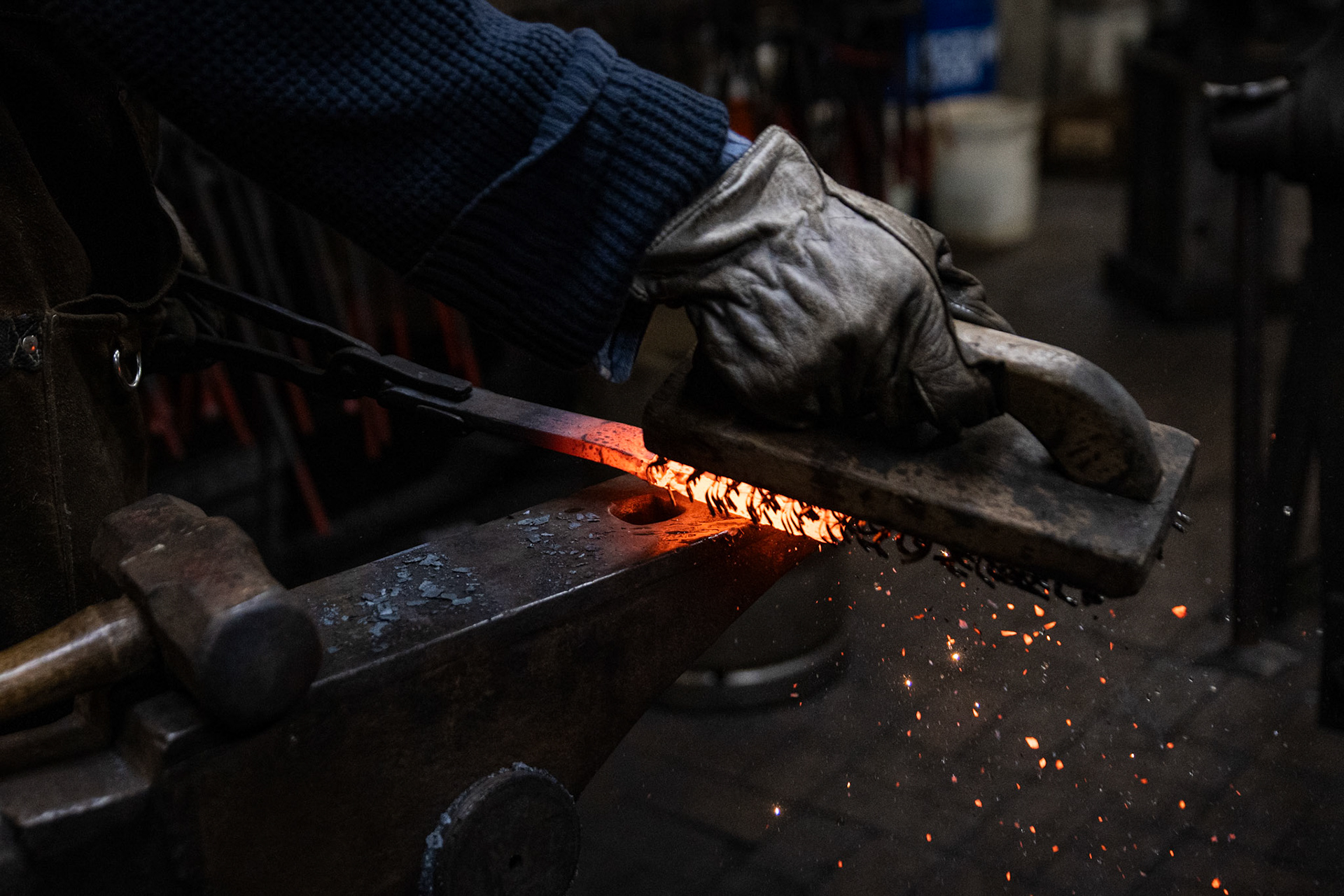 Cooper Guella brushes borax off a piece of iron, smoothing out the surface to prepare it for welding at the Blacksmiths Guild of the Potomac shop in Arlington, Va. on Nov. 10, 2025.