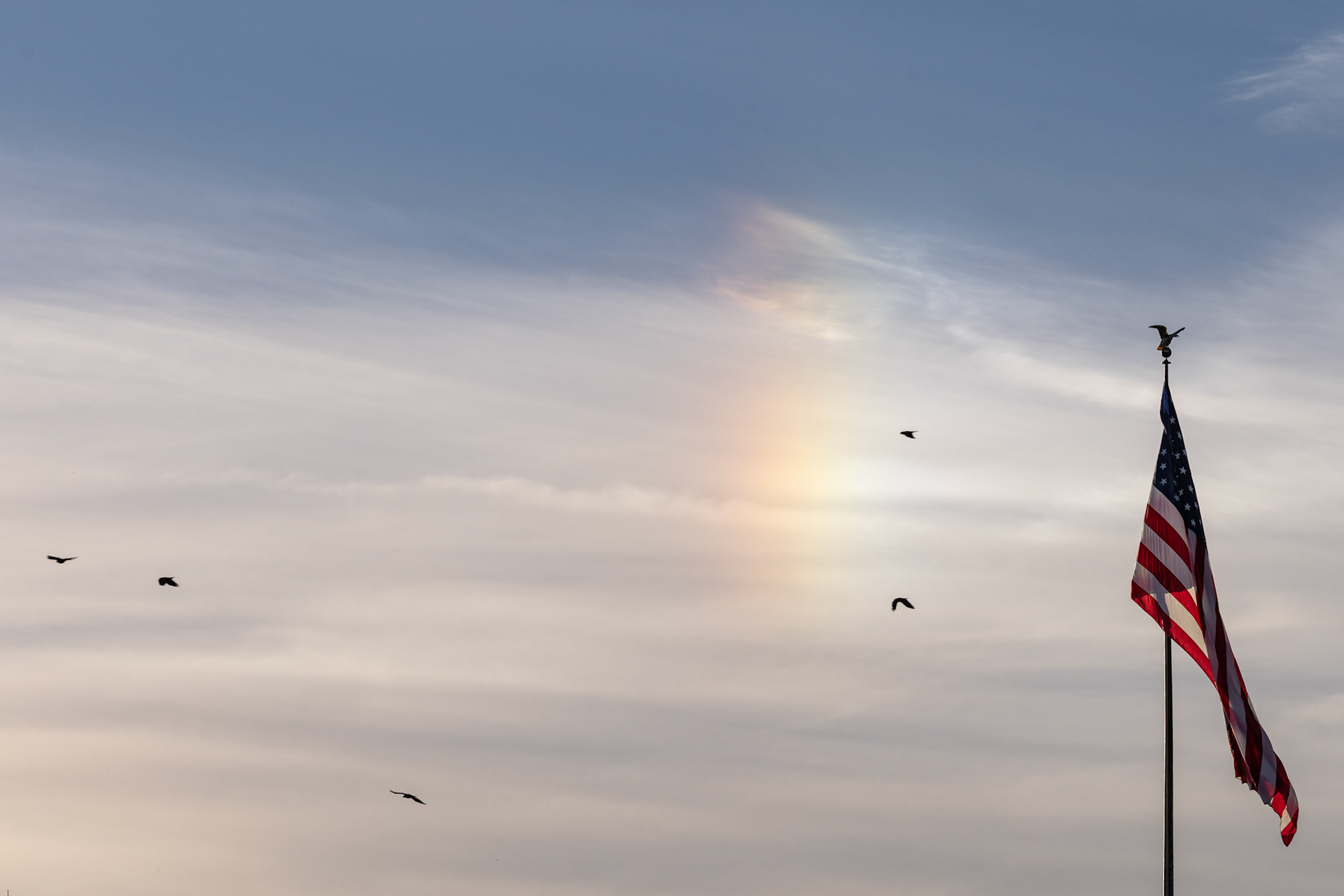 A rainbow forms beyond an American flag flying over the Department of State near the Lincoln Memorial after the Unite the DMV rally on Oct. 17, 2025. The protest, held on the eve of the No Kings march that drew millions across the nation, featured speakers and dancing to bring together community members speaking out against President Trump’s recent policies.