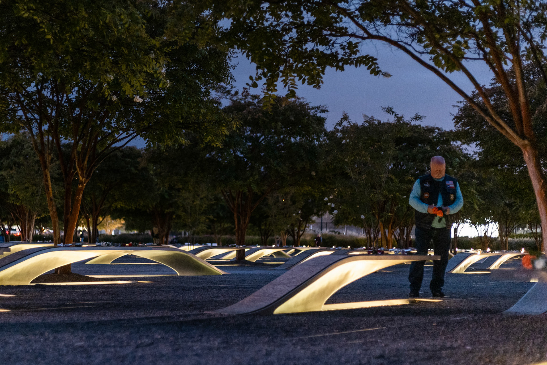 ARLINGTON, VIRGINIA - SEPTEMBER 11: A member of the Northern Virginia Christian Riders researches the person whose bench he prepares to lay roses on at the Pentagon Memorial on Sept. 11, 2025. Each year, multiple motorcyclist groups from throughout the area gather at the memorial for a ceremony to honor the victims of the attack and recognize the sacrifices they made.