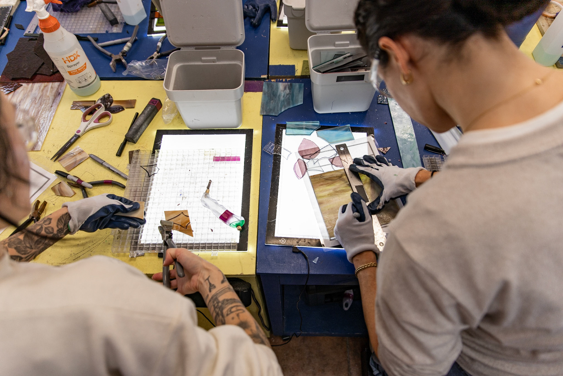 Students cut sheets of glass during an introductory stained glass making class at Fiscus Glassworks in Alexandria, Va. on Nov. 08, 2025.