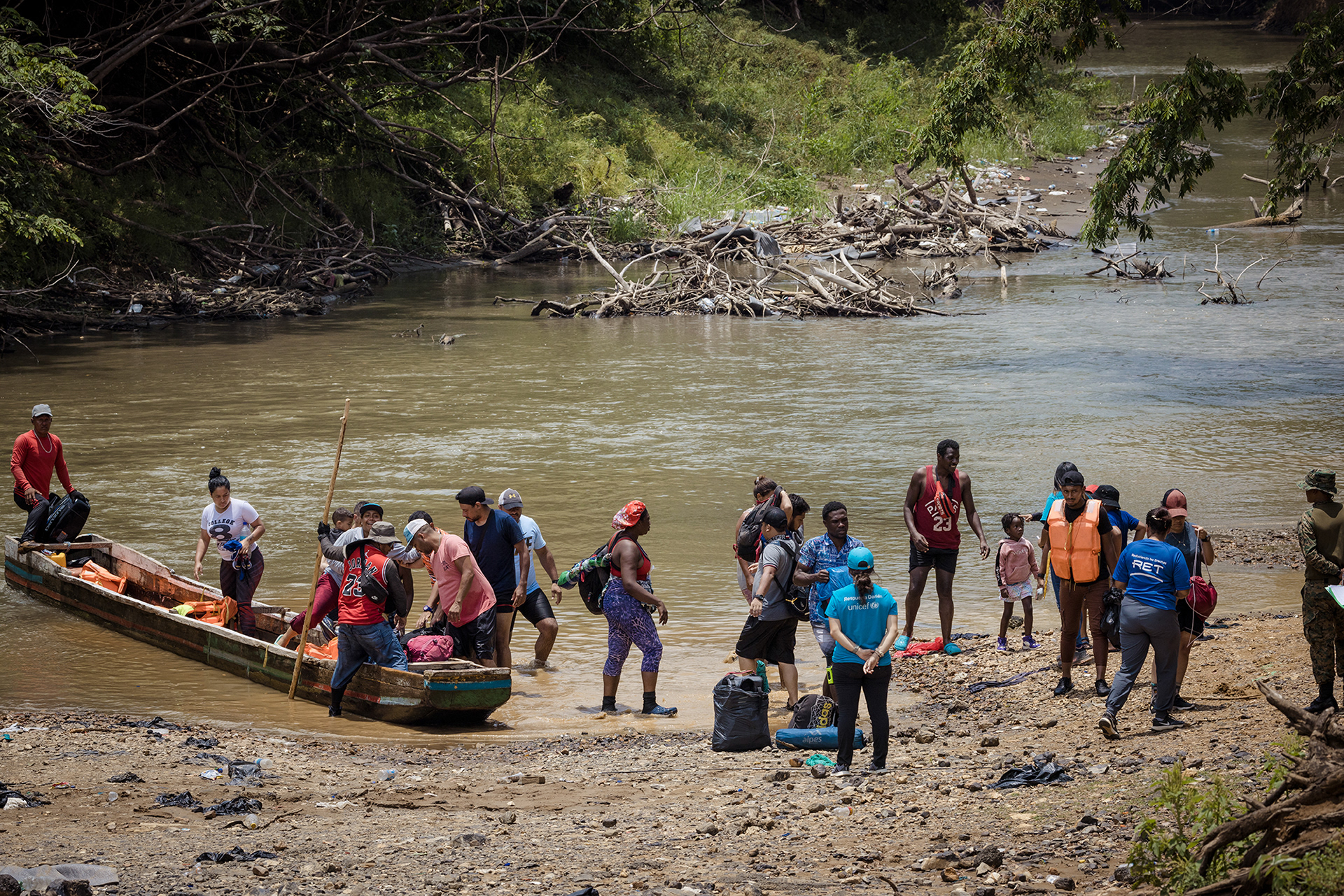 Migrants disembark from a canoe at the banks of Las Lajas Blancas camp, continuing their journey to the US.
