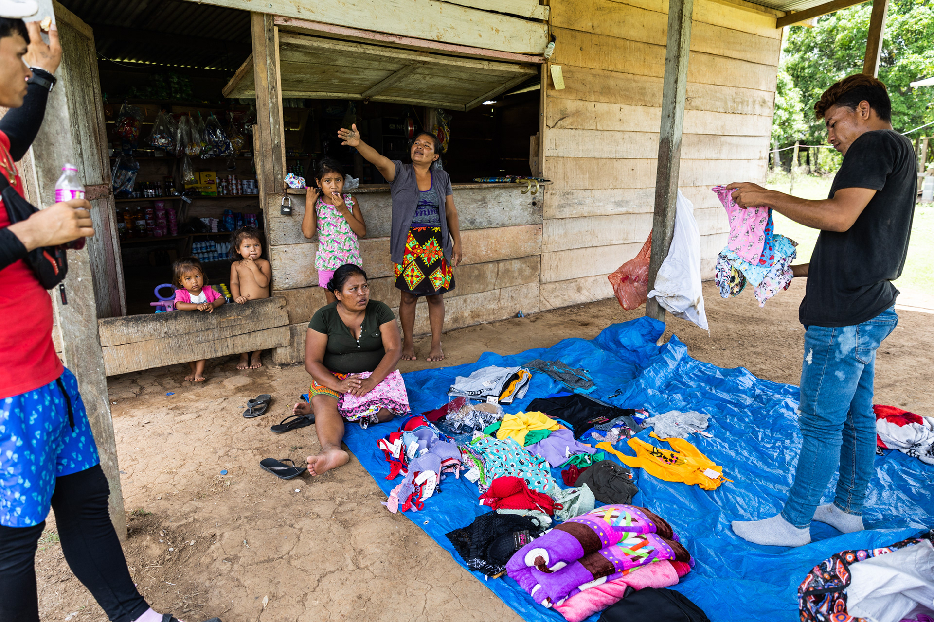 An Emberá family arranges inventory at their clothing store, preparing for the steady flow of migrants needing supplies.