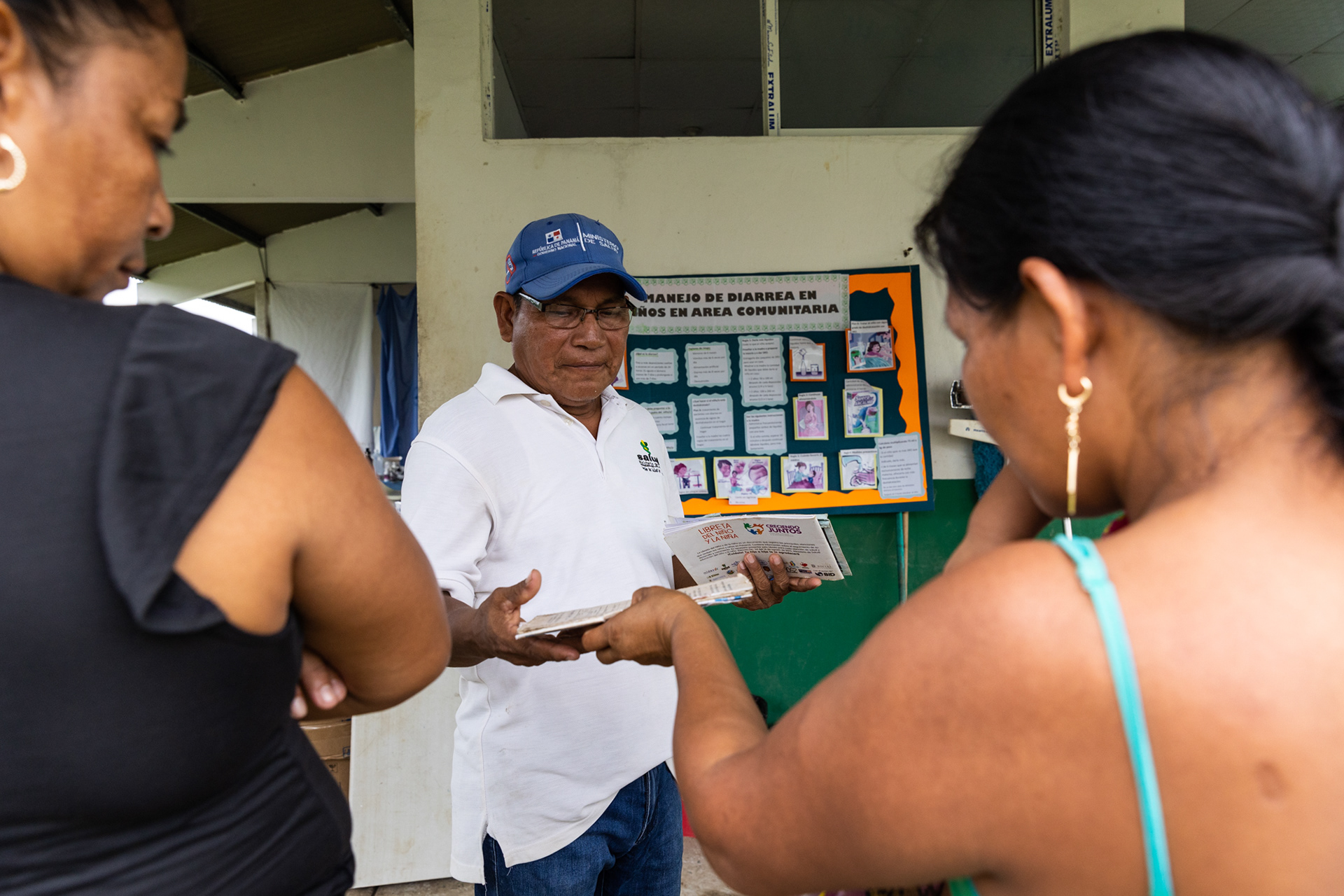 Two Emberá women wait at a health center built to serve migrants, now benefiting local residents with improved healthcare access.