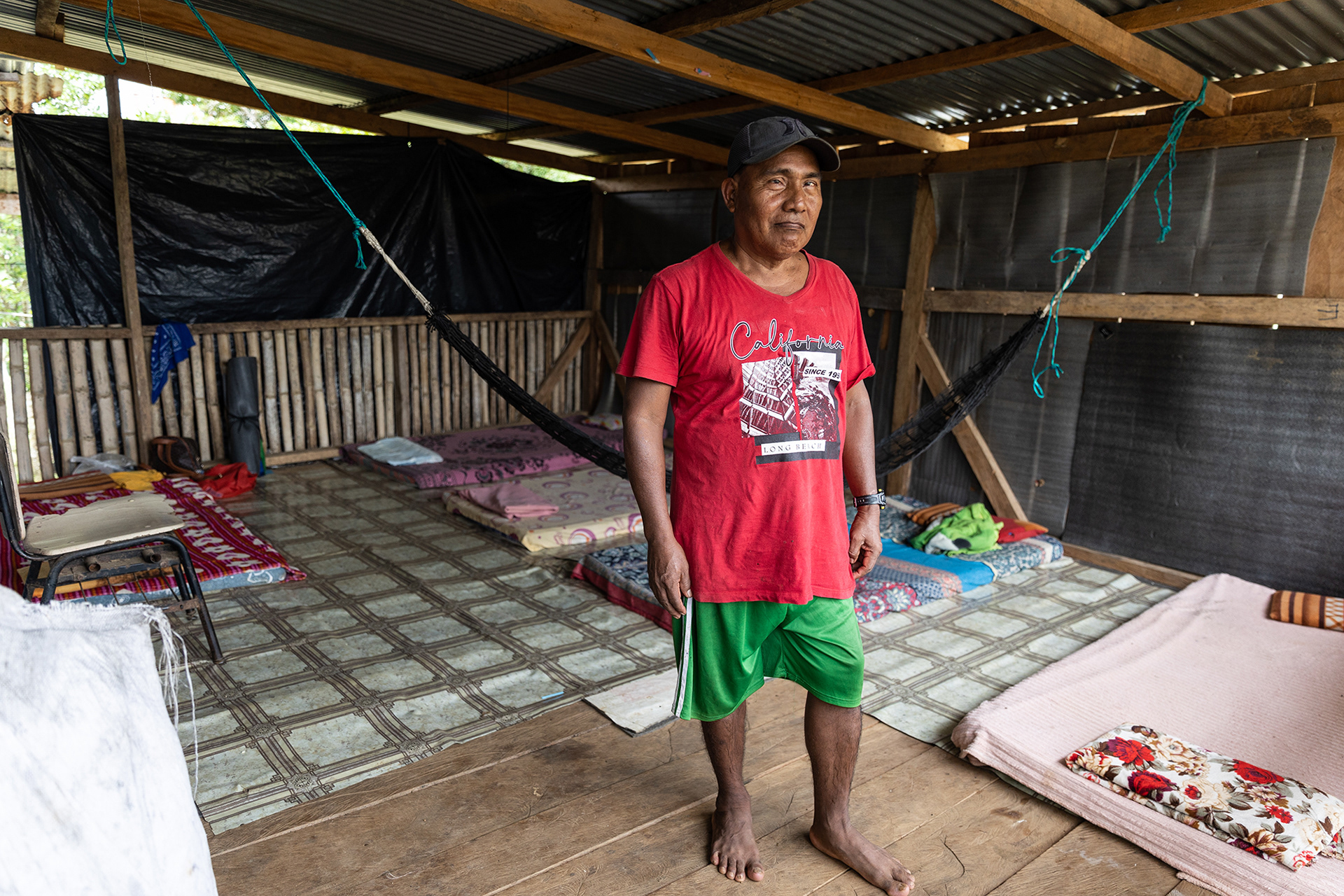 An Emberá man stands in his hostel, where migrants can rent mats and hammocks for $5 a night.