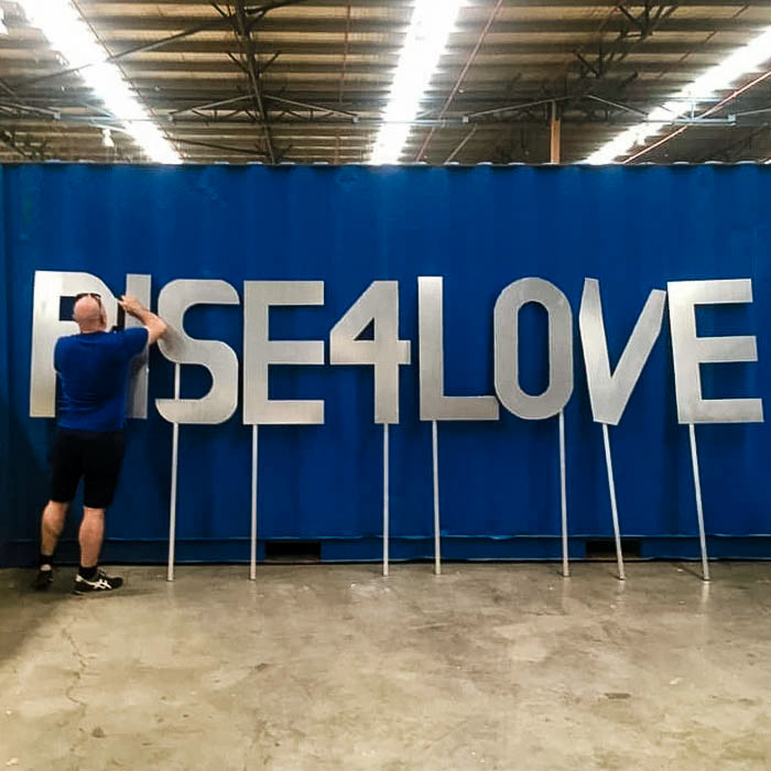 Markham Lane prepares the final messaging props for the Colours of Our Community float in the 2021 Sydney Mardi Gras Community Workshop. Photo by Jane Becker.