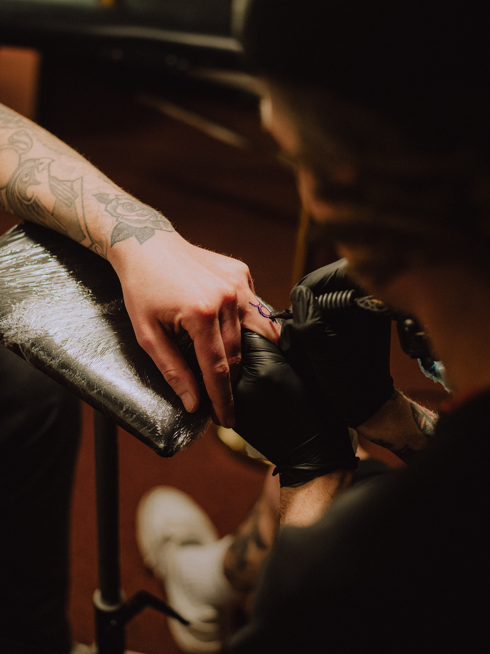 Risk tattoos Stefan in his makeshift studio. Rotterdam, 2023.