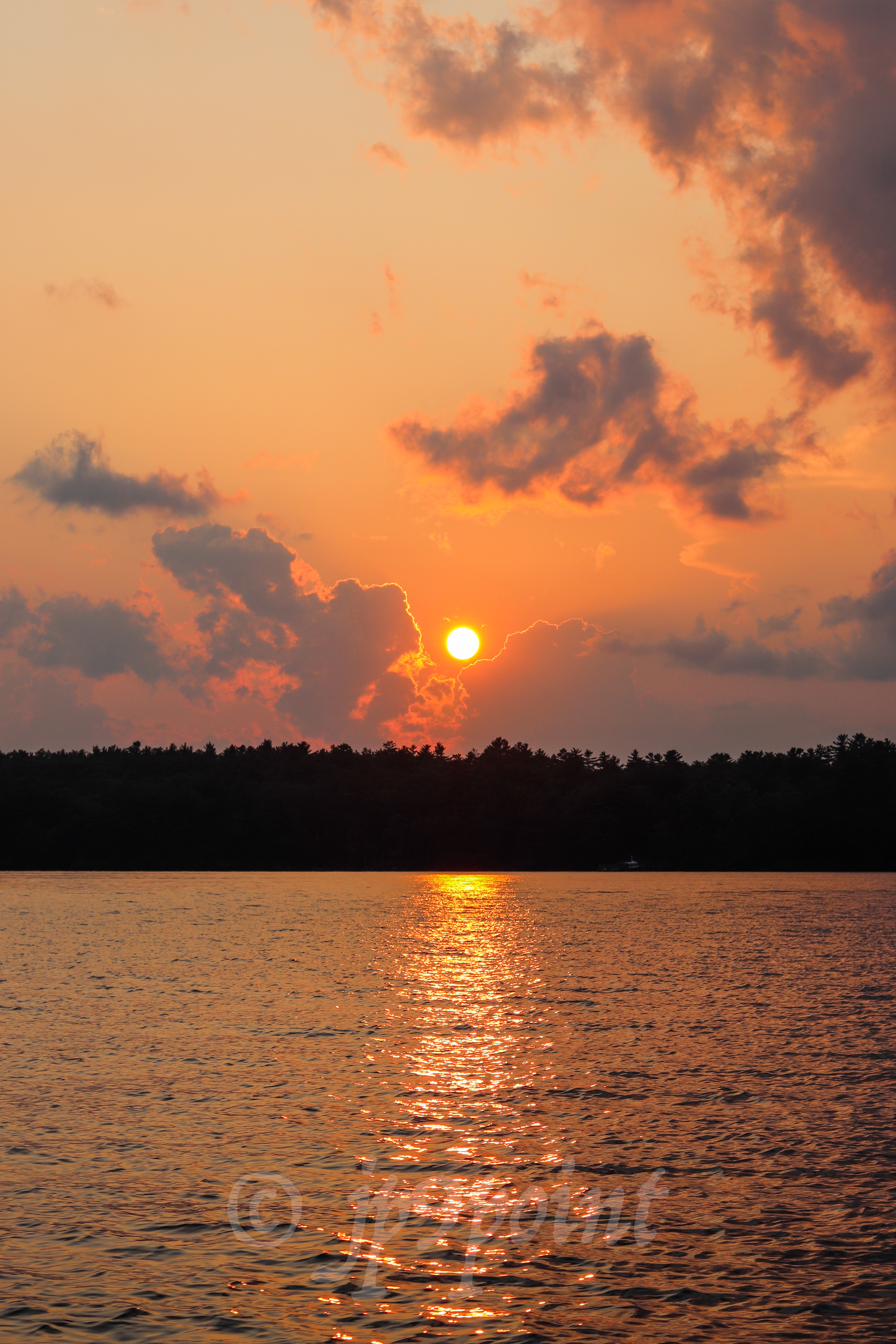 Bright orange sunset over Lake Winnipesaukee, New Hampshire.