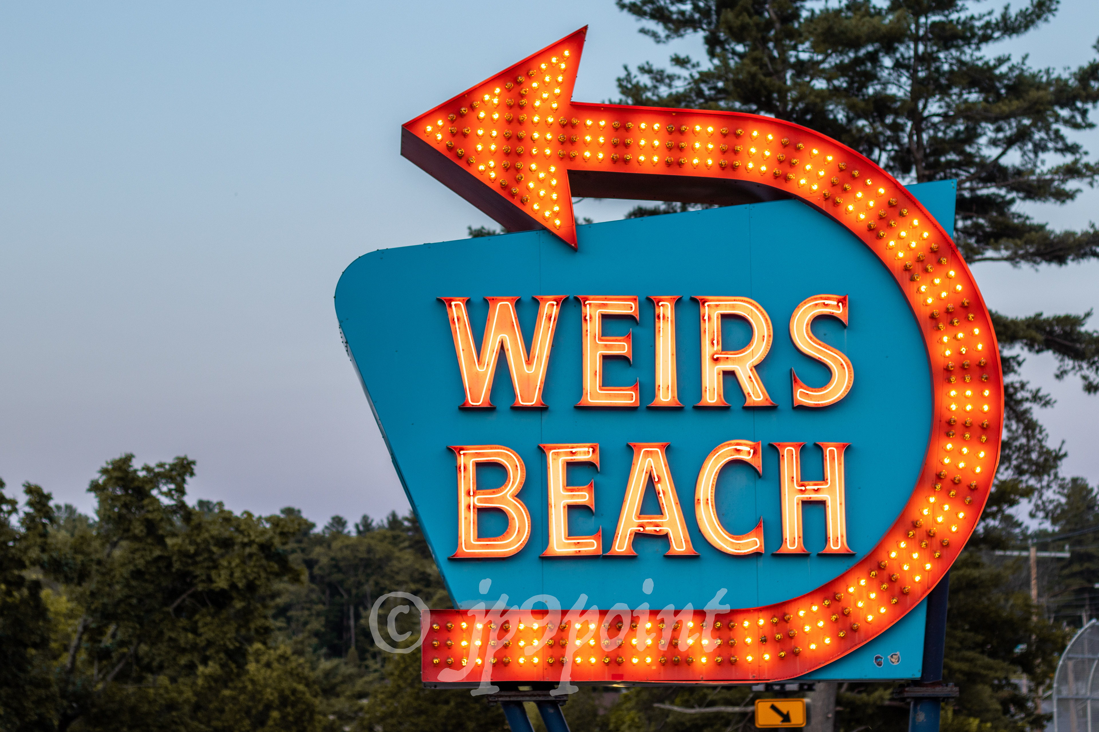 Weirs Beach sign lit up at night