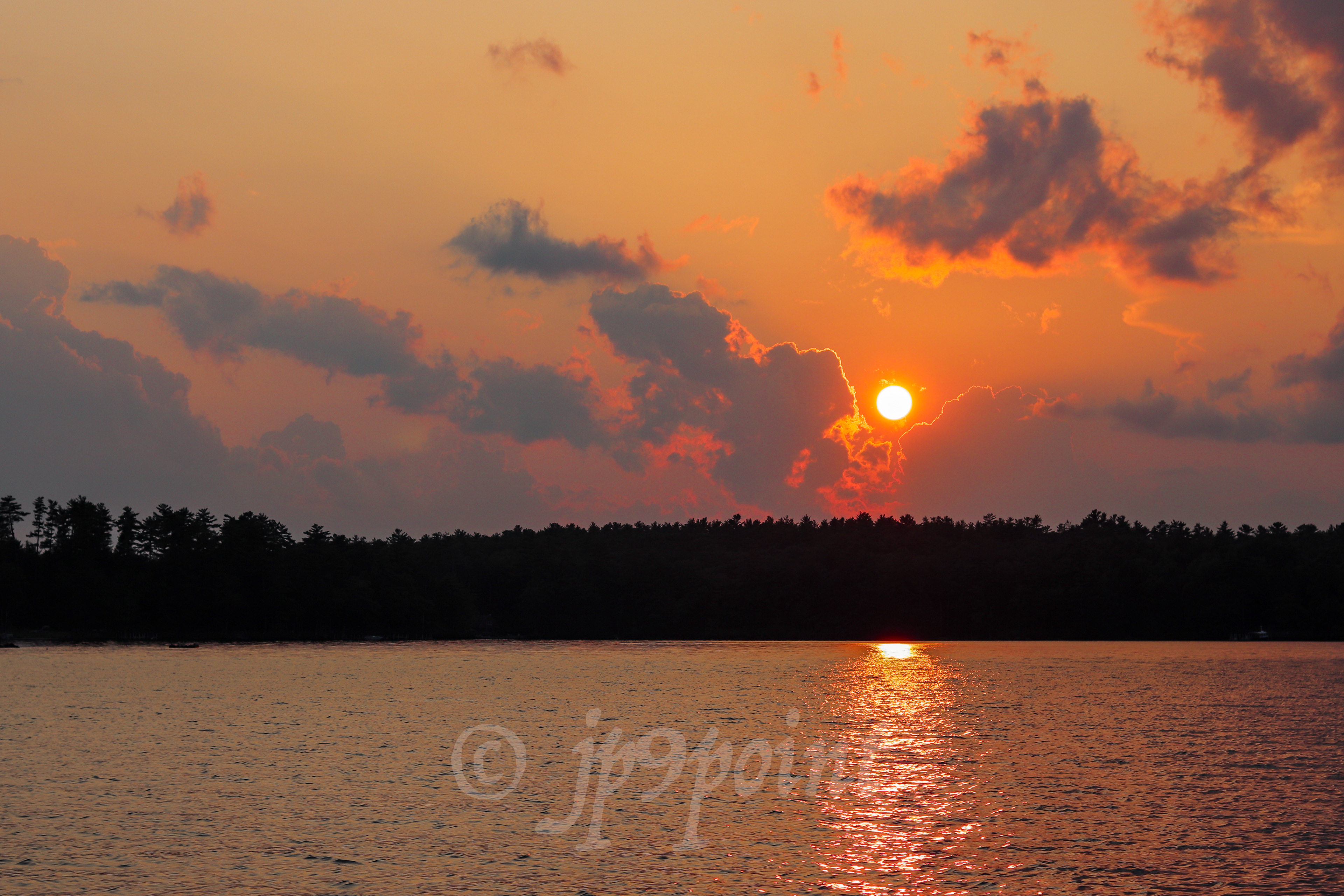 Bright orange sunset over Lake Winnipesaukee, New Hampshire.