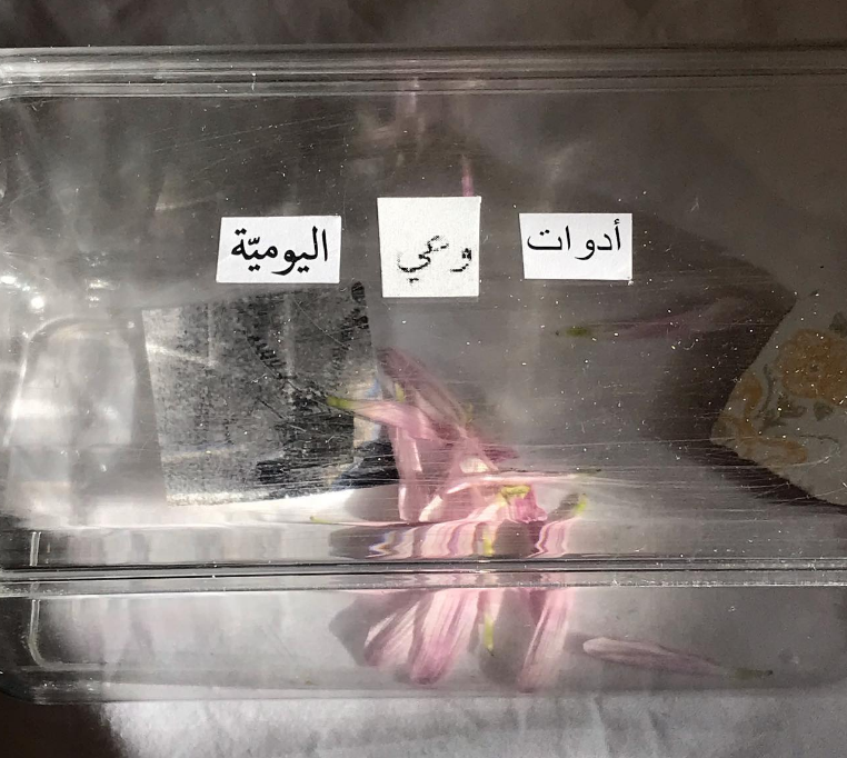 Detail (text collage and found objects) — Text in image (Arabic → English): 'Tools of daily awareness'