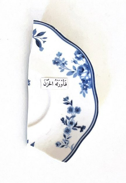 Detail (text collage and found object) — Text in image (Arabic → English): 'So he bequeathed him sorrow'