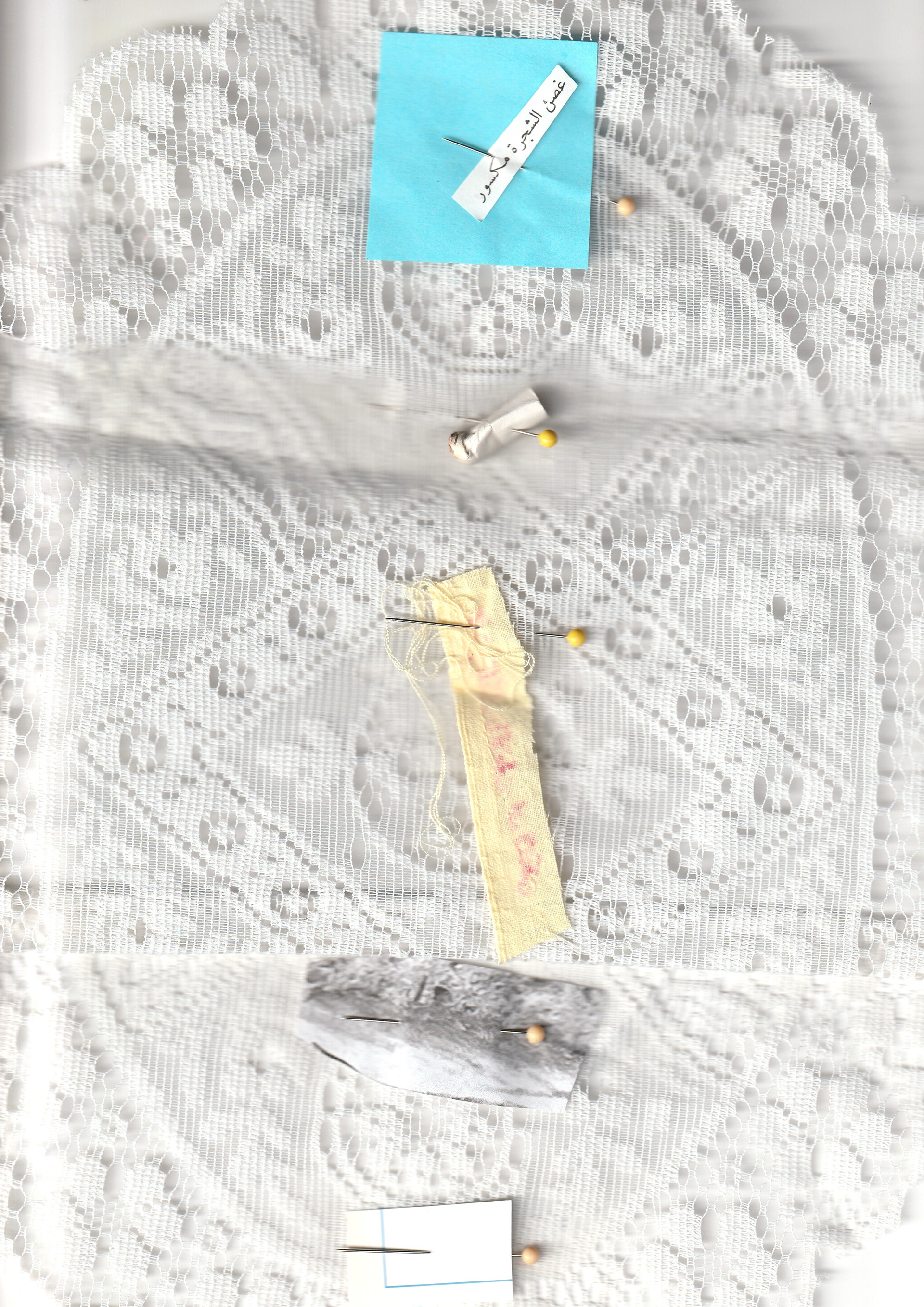 Detail (text collage and found objects) — archival family photograph; Text in image (Arabic → English): 'The tree branch is broken.'