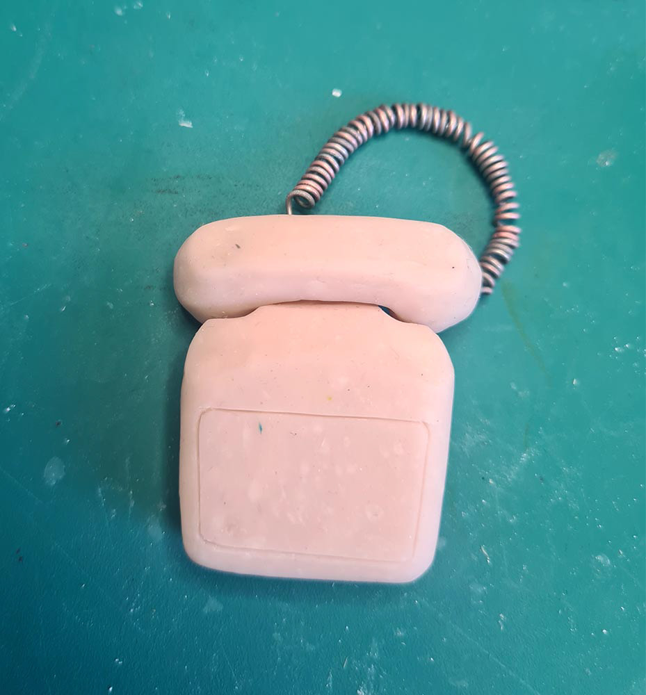 A mini phone made from polymer clay and wire.