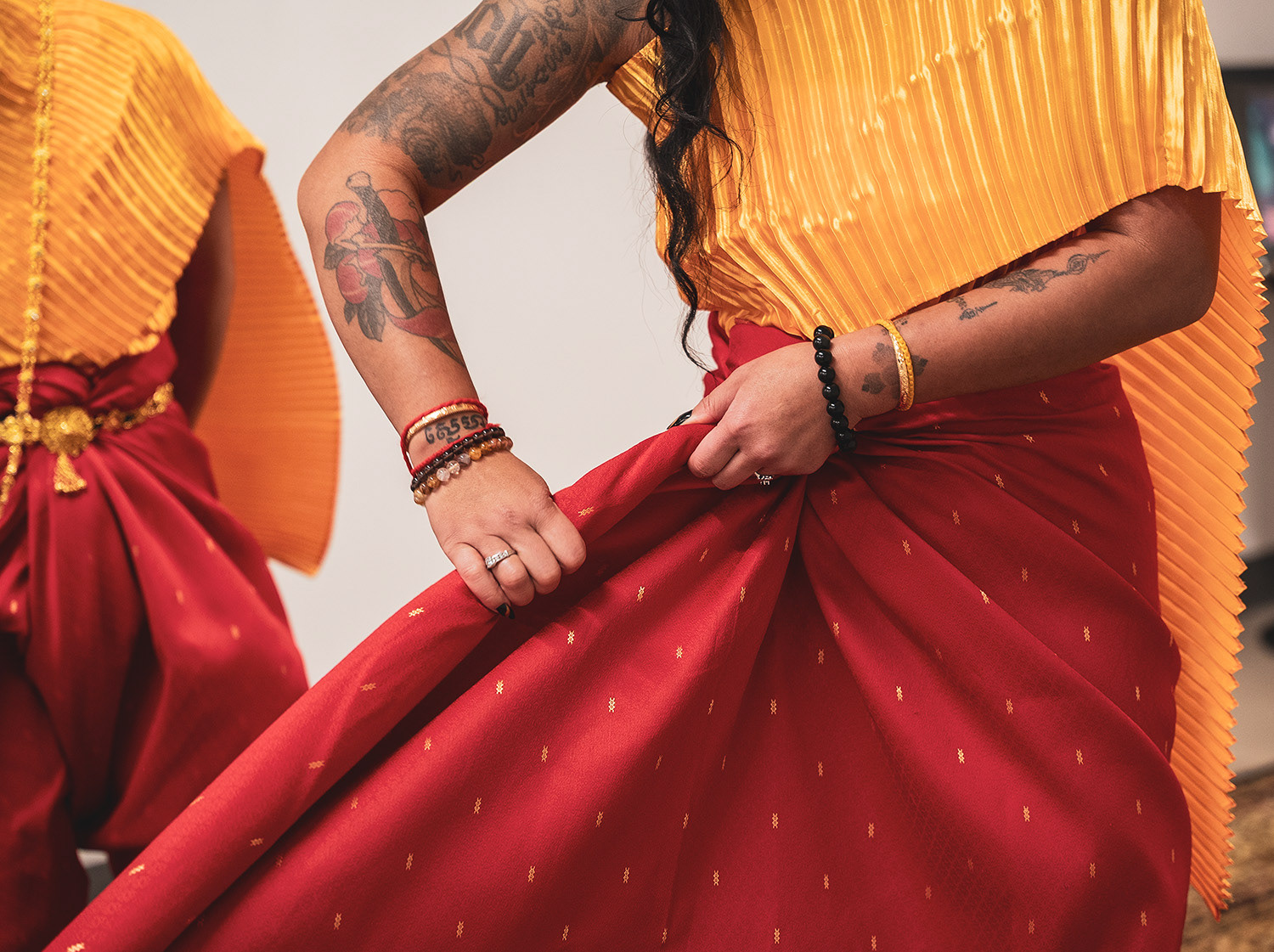 A dancer rolls the cloth before it is tied and pinned. 