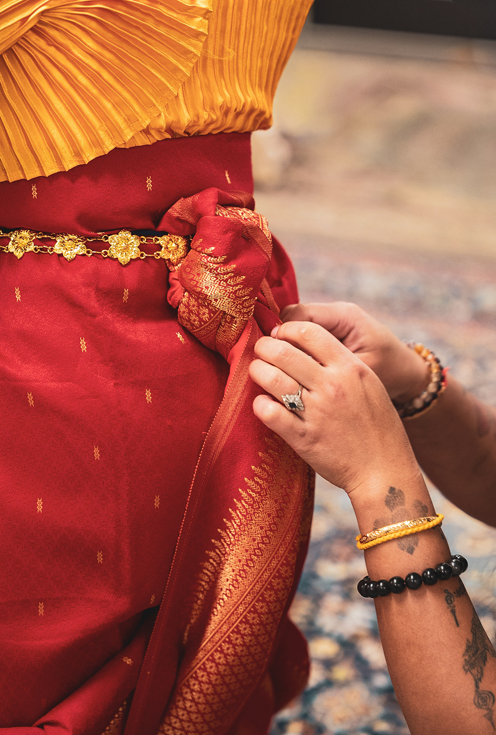 A dancer carefully knots and pins the traditional garb. 