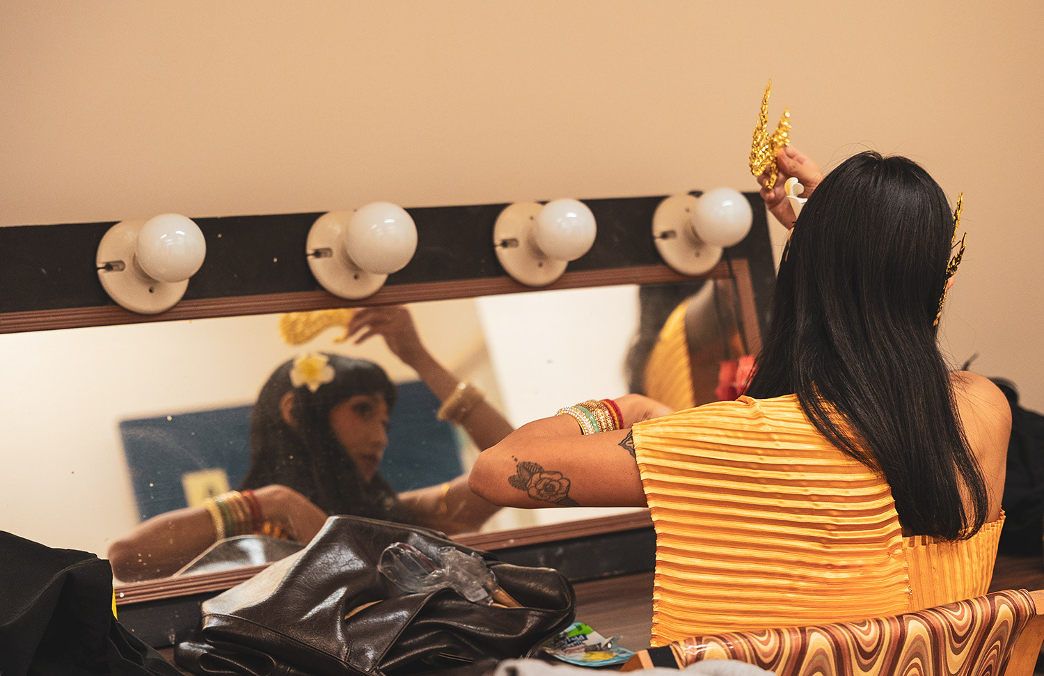A dancer pins Naga ears to her hair in the dressing room as the last adornment before the performance. 