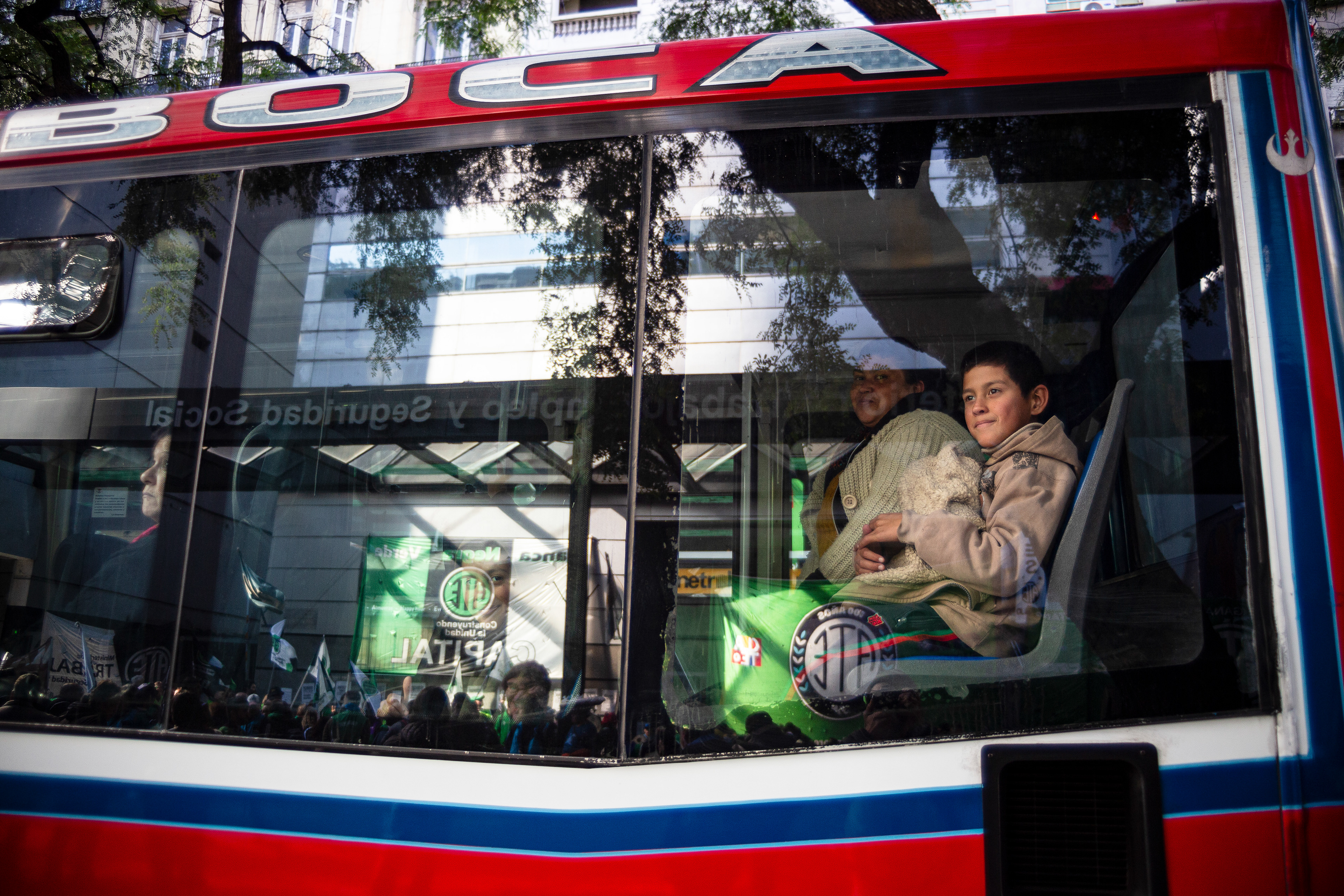A child and his mother watch a state workers' union (ATE) demonstration from inside a public bus in Buenos Aires, Argentina. May 16, 2024. (Photo by Catriel Gallucci Bordoni)
