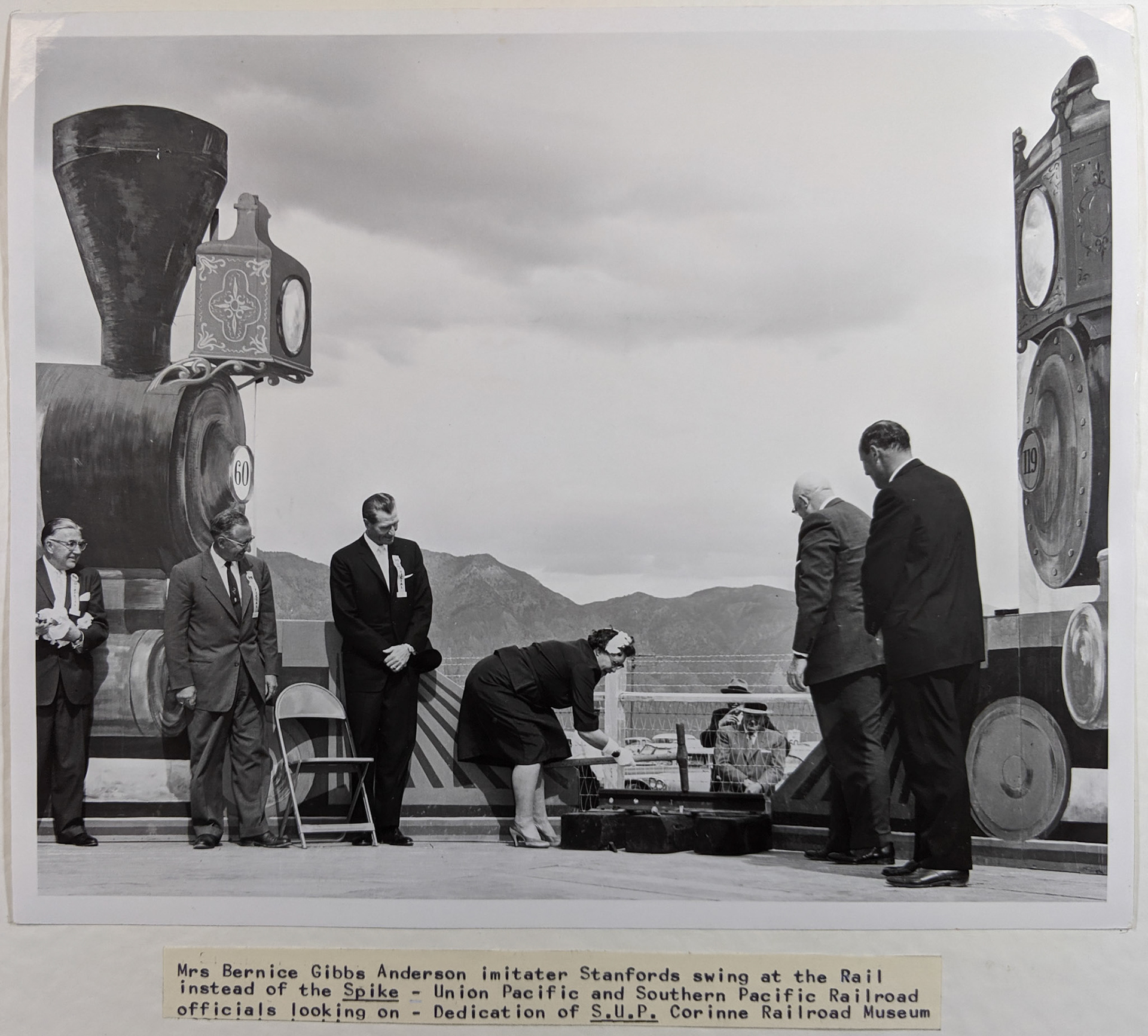 Bernice Gibbs Anderson imitates Stanford's swing at the rail, UPRR and SPRR officials at dedication of SUP Corinne Railroad Museum. Bernice Gibbs Anderson Collection, NPS