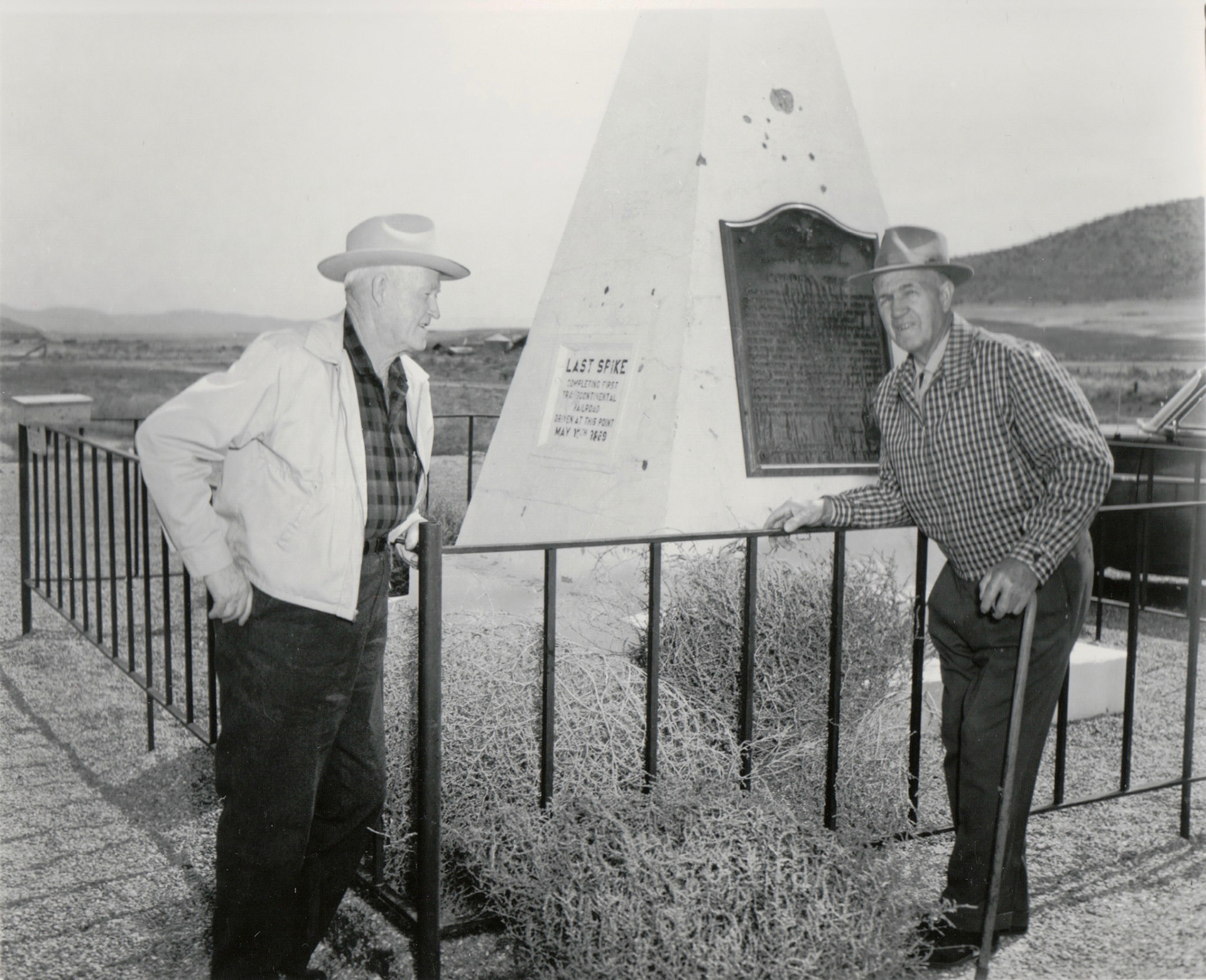 Two men at Golden Spike obelisk monument, circa 1954, Promontory Summit, Utah. Bernice Gibbs Anderson Collection, NPS
