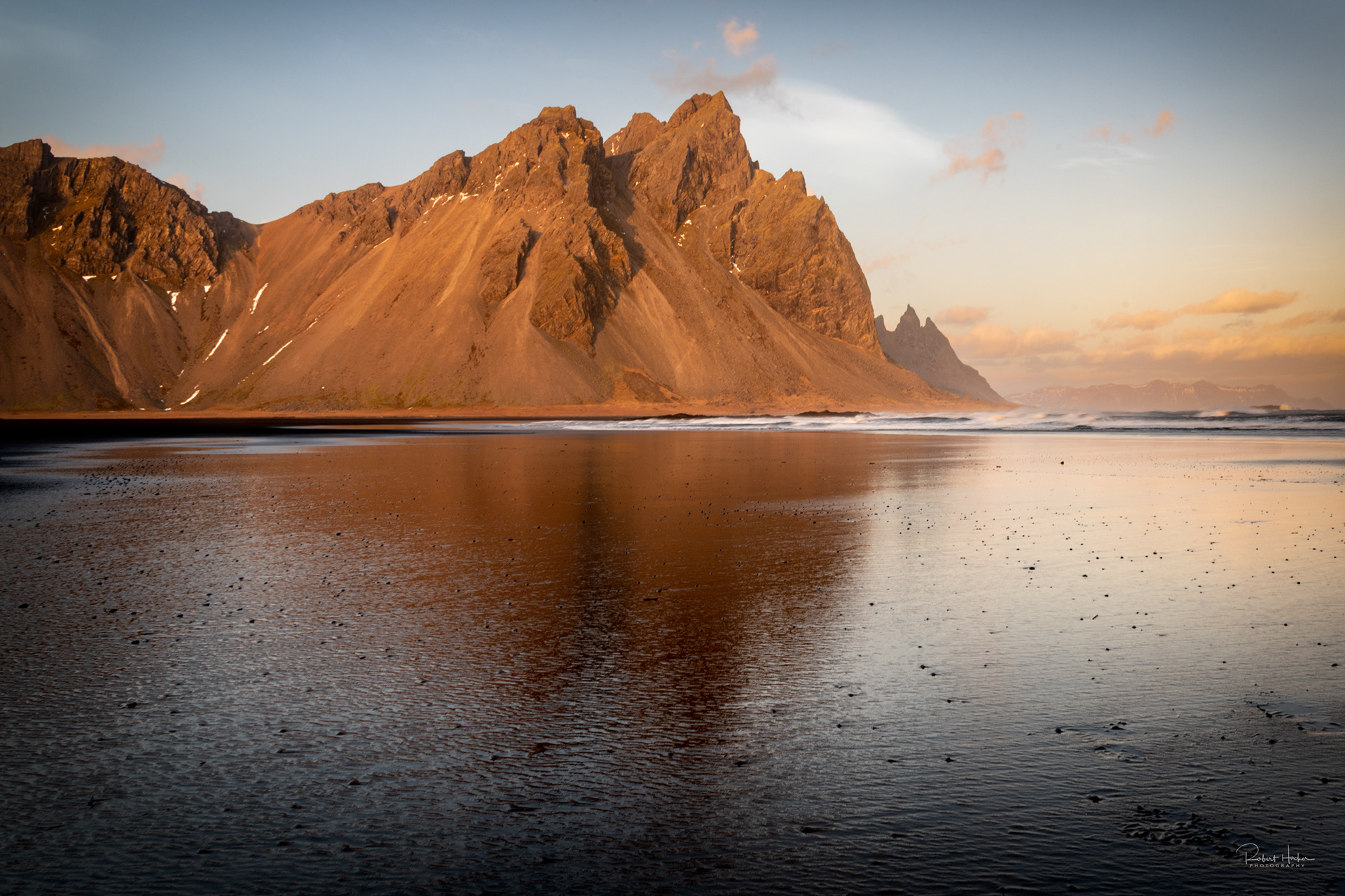 Vestrahorn reflected in the wet black sand beach
