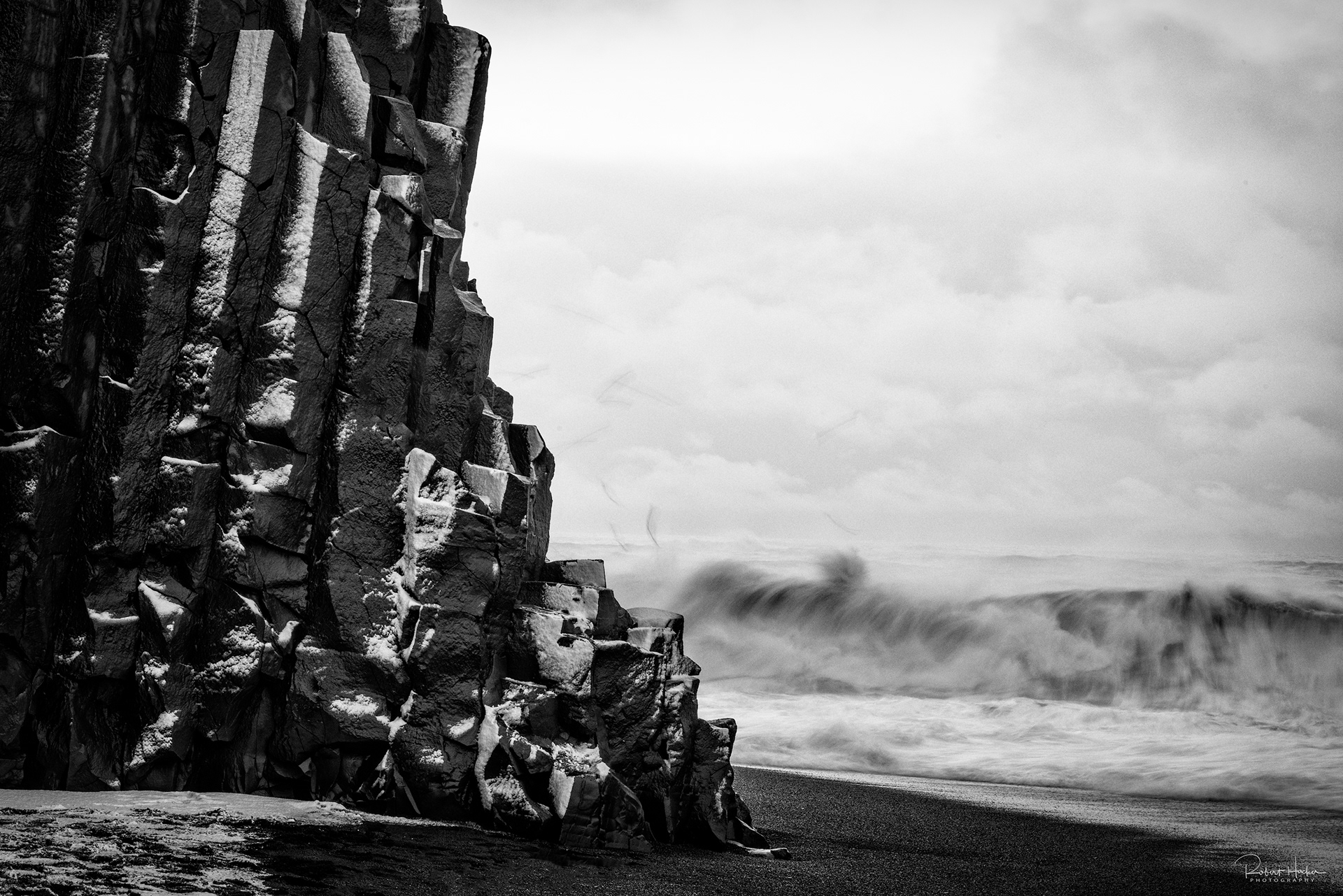 Basalt cliffs and crashing surf at Reyniskirkja Beach
