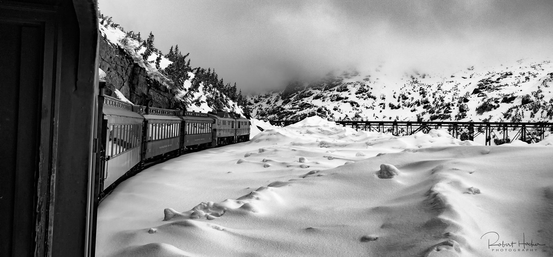 View of a snow field and the train taken from between cars on the White Pass & Yukon Route Railway